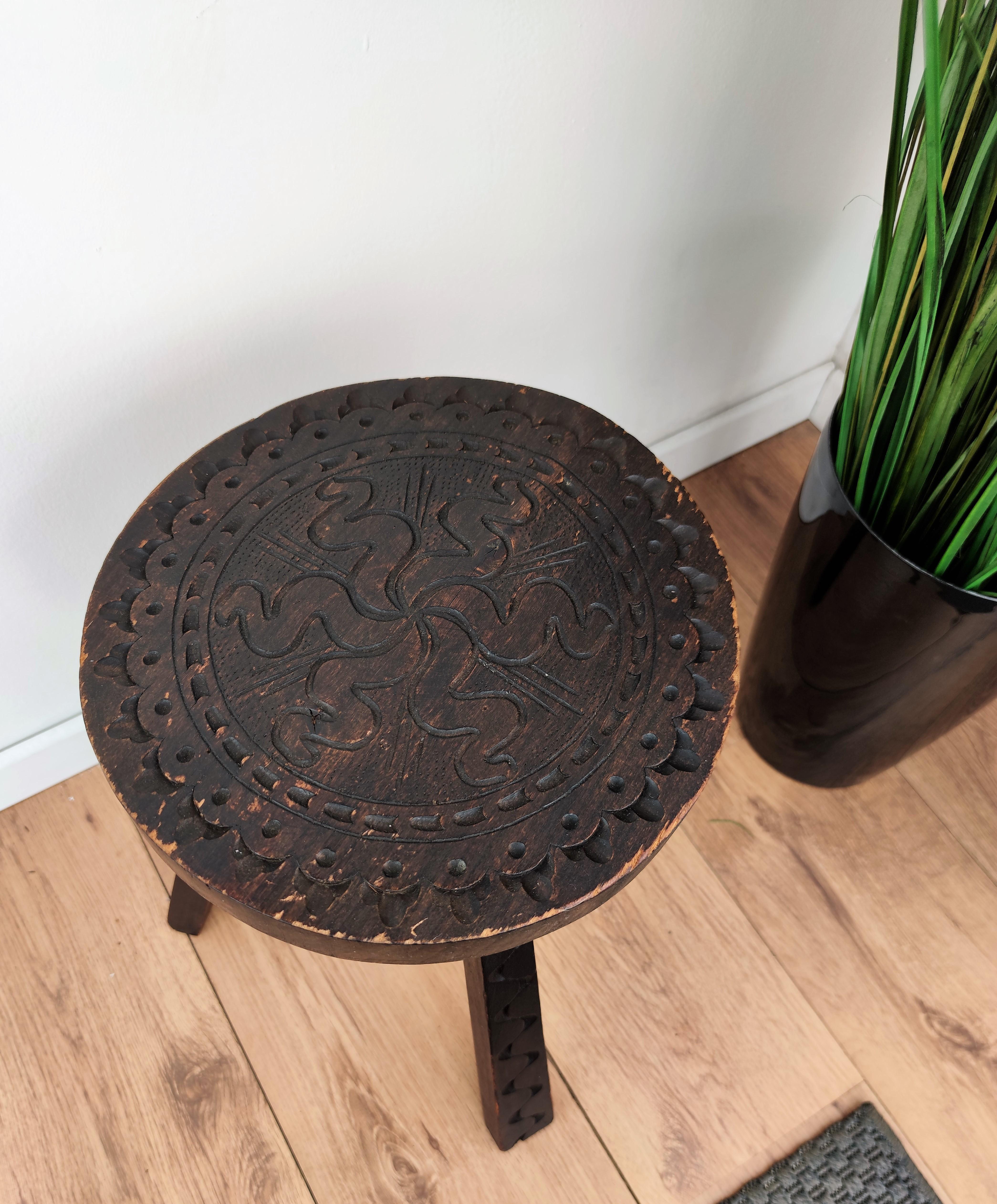 Beautiful Italian tripod stool or chair in carved wood with round top seat and detailed carving on each of the three legs.