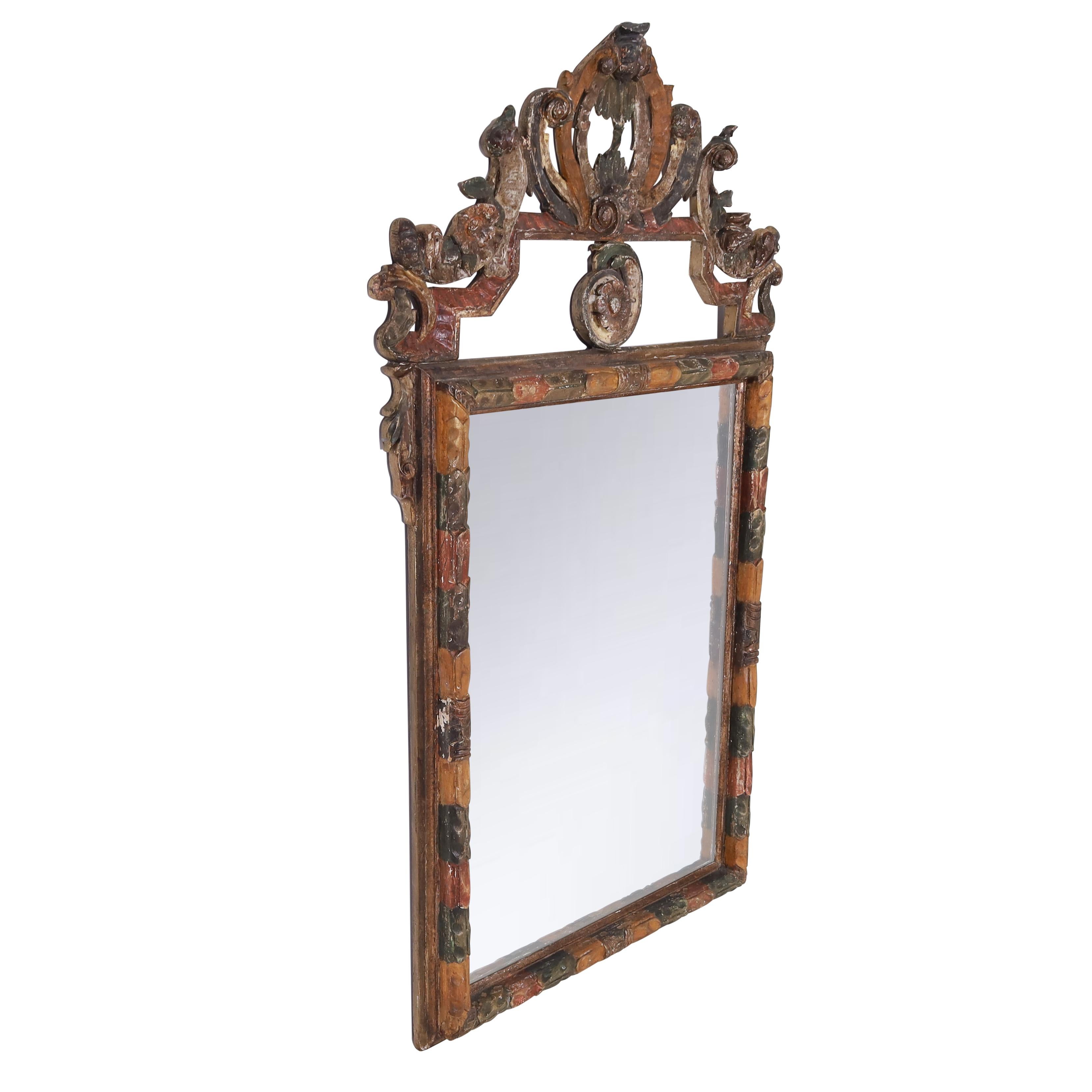 Impressive 18th century Italian Rococo wall mirror hand crafted in walnut, carved in classic floral motifs,gessoed and decorated with distinctive mediterranean colors now aged to perfection.