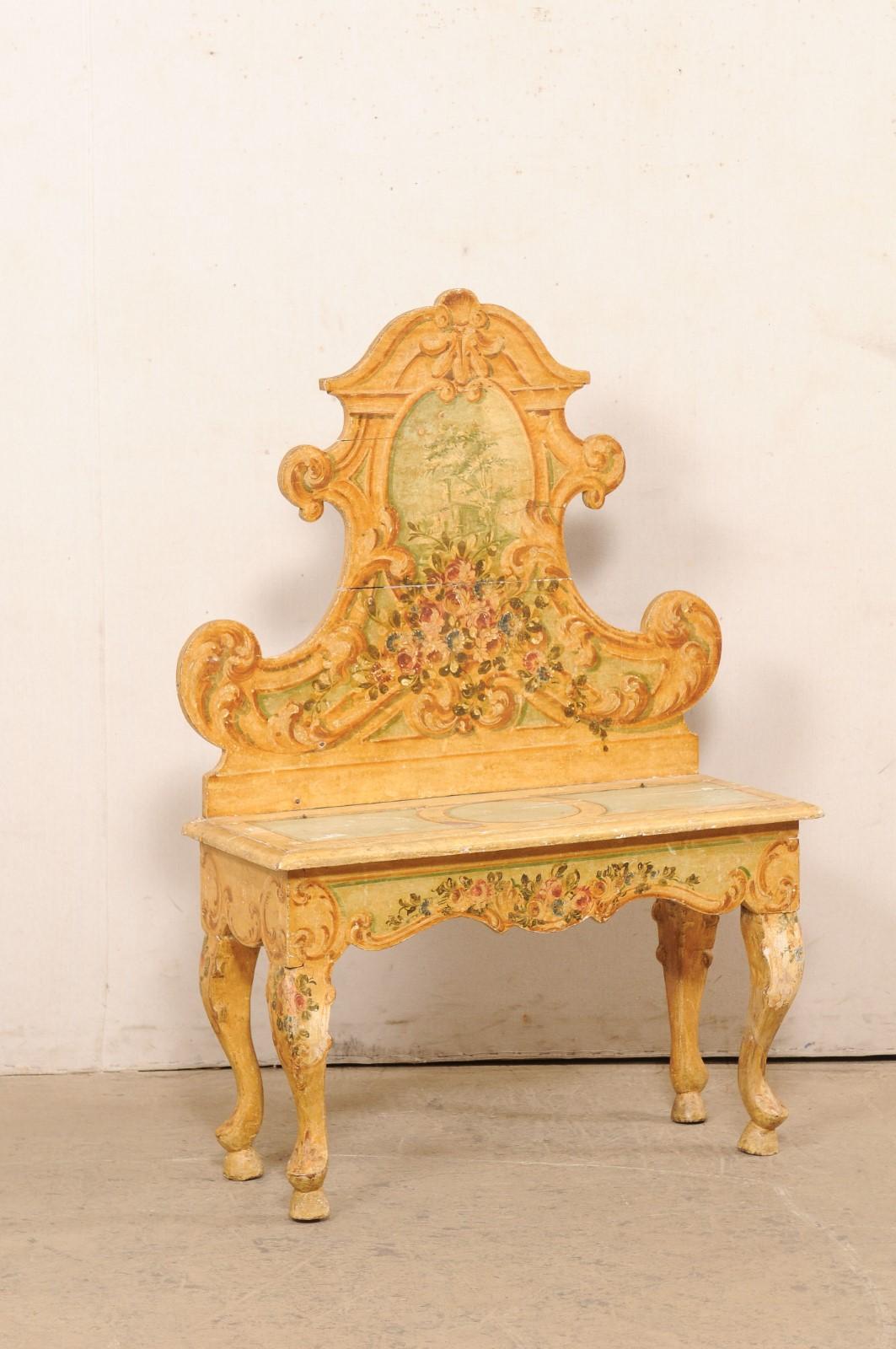 An Italian carved and hand-painted cassapanca (chest bench) from the early 20th century. This antique bench from Italy has an elaborately carved shapely pediment-style back, a scalloped skirt, and is presented on four cabriole legs. The seat has a