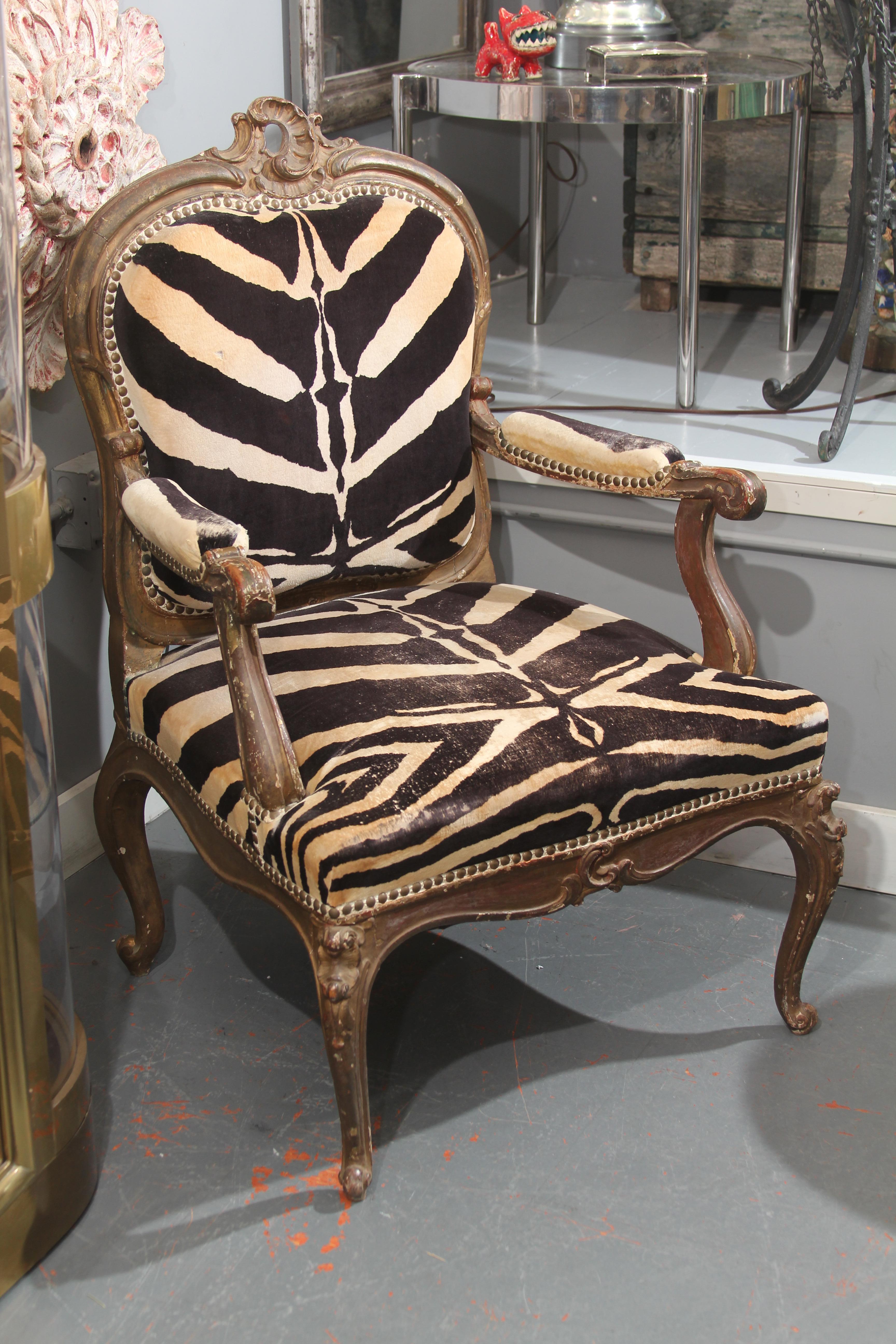 Curvy 19th century antique carved giltwood Italian chair upholstered in beautifully worn cotton velvet. Sturdy and comfortable, this is a very versatile and useable chair for almost any room. The care that was taken for fabric placement is top