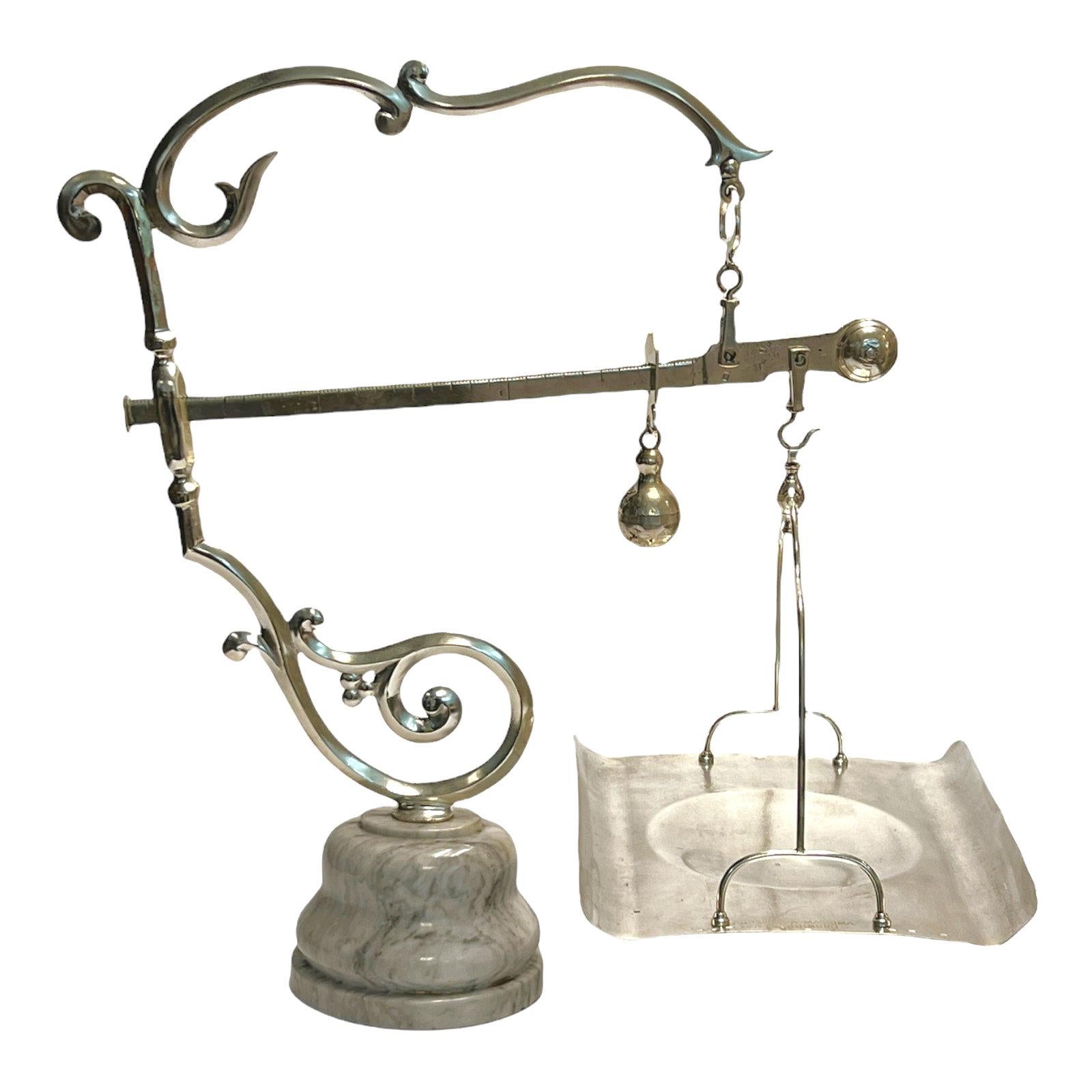 Our elegant antique Italian mercantile scale, circa 1880s, is crafted from chromium plated brass and steel with an oval shaped, variegated blue and white marble base. With various stamped calibration marks. Tray is stamped 15KG PORTATA MASSIMA