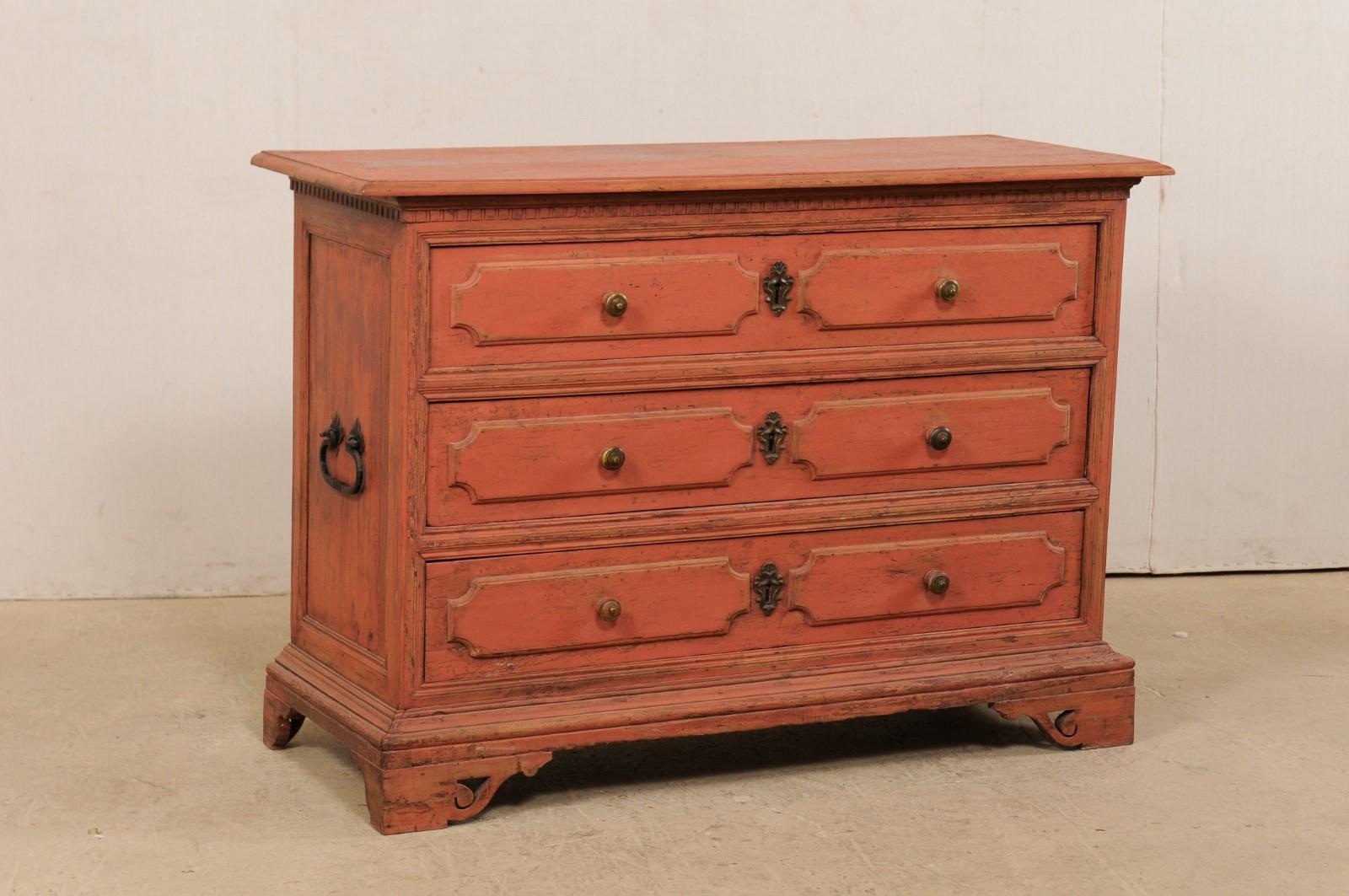 An Italian 19th century carved and painted wood chest of drawers with later additions. This antique commode from Italy features a rectangular-shaped top with dental carved accent trim beneath, a case which houses three full-sized and graduated
