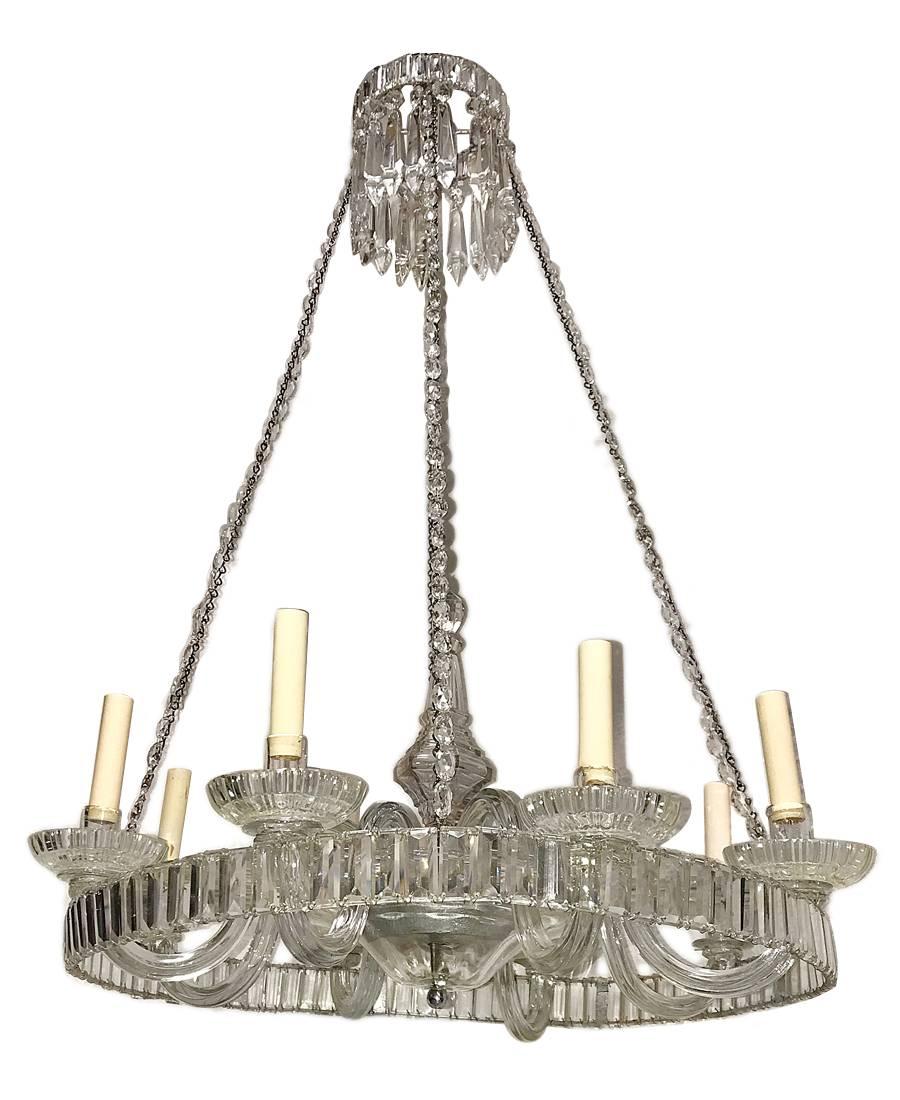 A circa 1930's English crystal chandelier with 8 lights and with a ring of crystal on the body.

Measurements:
Diameter: 28