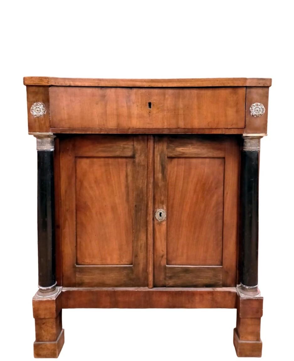 Antique Italian Empire cabinet from the early 19th century

Small empire cabinet, particular cabinet from the empire era (circa 1840).
Italian, with entire column, ebonized and brass capitals.
The drawer is curved and the top is slightly inclined so