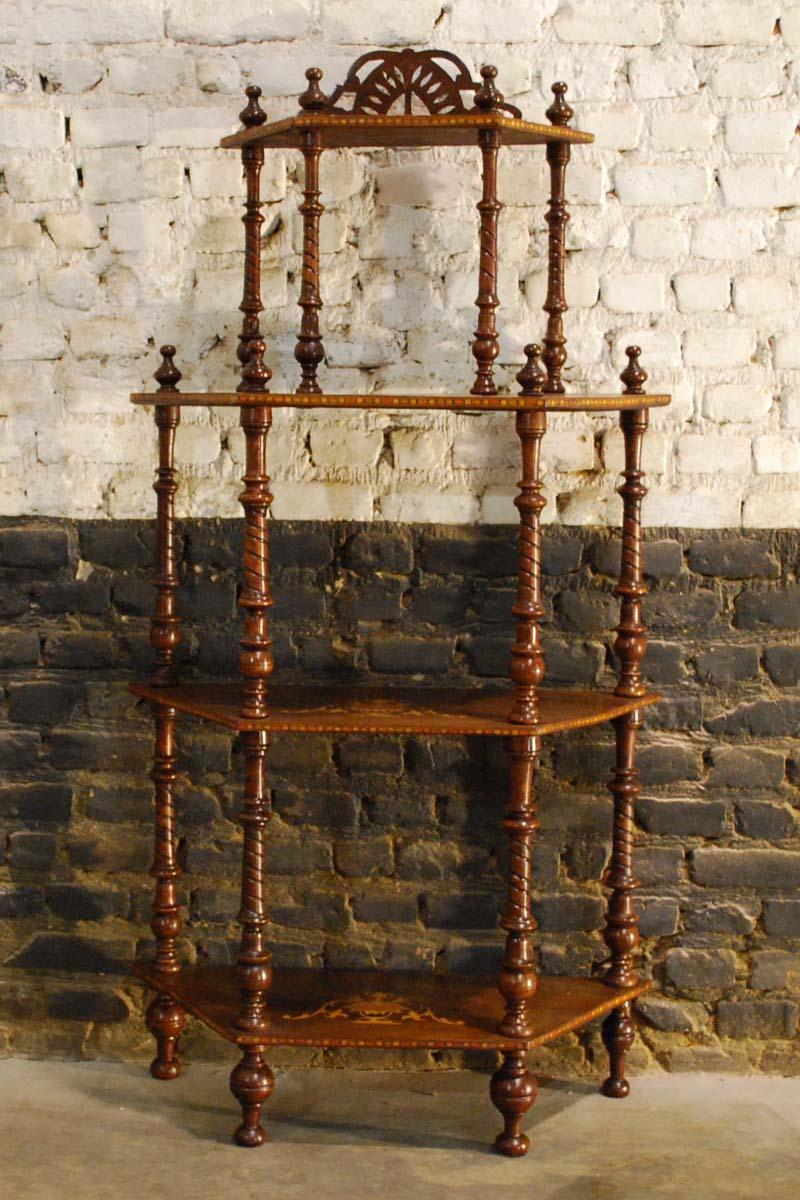 A delicate Italian étagère with four shelves on turned columns with finials on top.
The étagère is made in walnut and has intricate inlaid designs in mahogany that is also called intarsia.
It also features crossband inlay on each shelve. The étagère