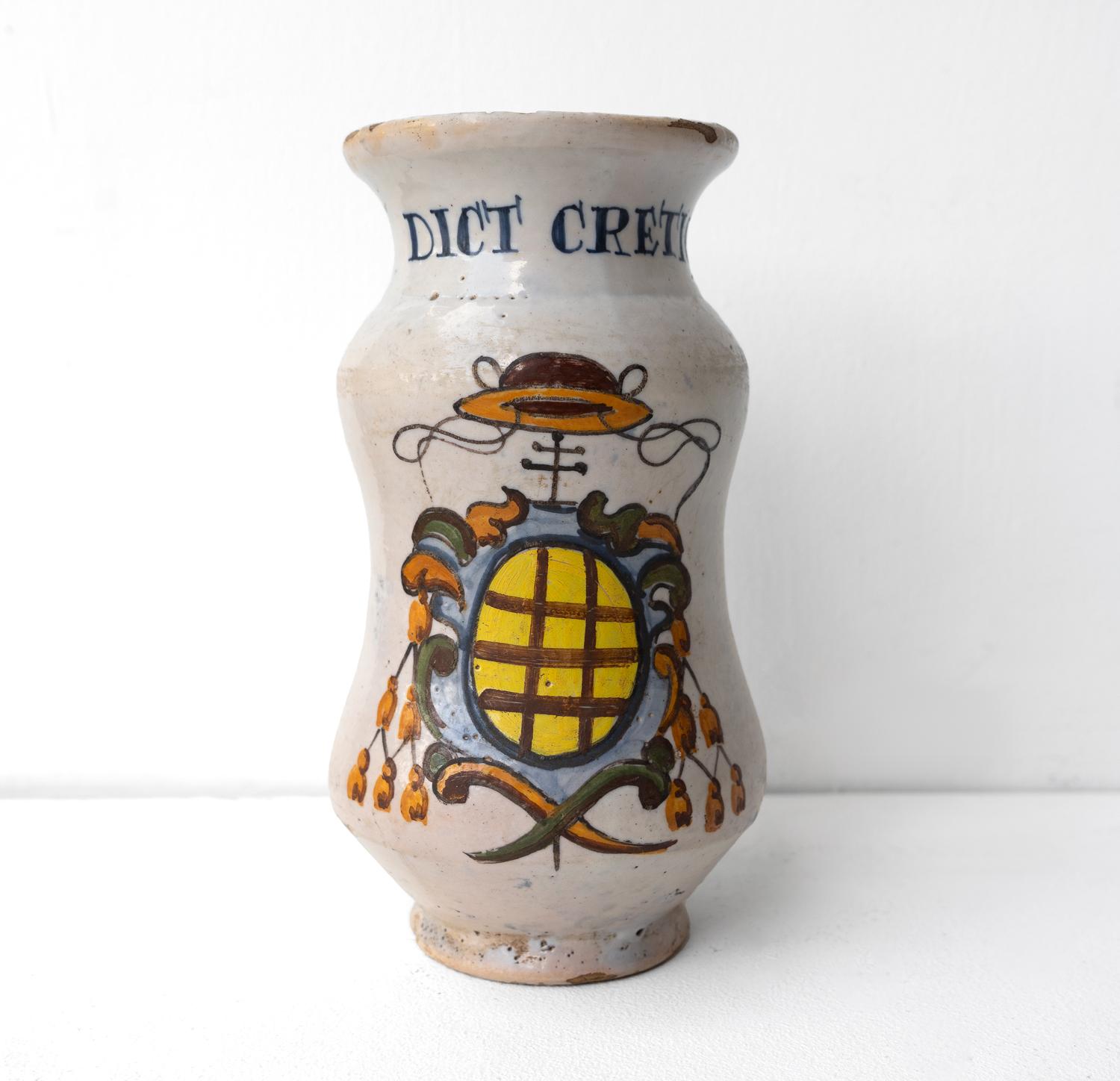 ANTIQUE GLAZED CERAMIC DRUG STORAGE JAR 
An original 18th-century glazed ceramic drug jar or ‘albarello’.

Of waisted form with hand-painted polychrome crest and script reading ‘DICT CRETIC’.

It is in very good vintage condition for its age, there