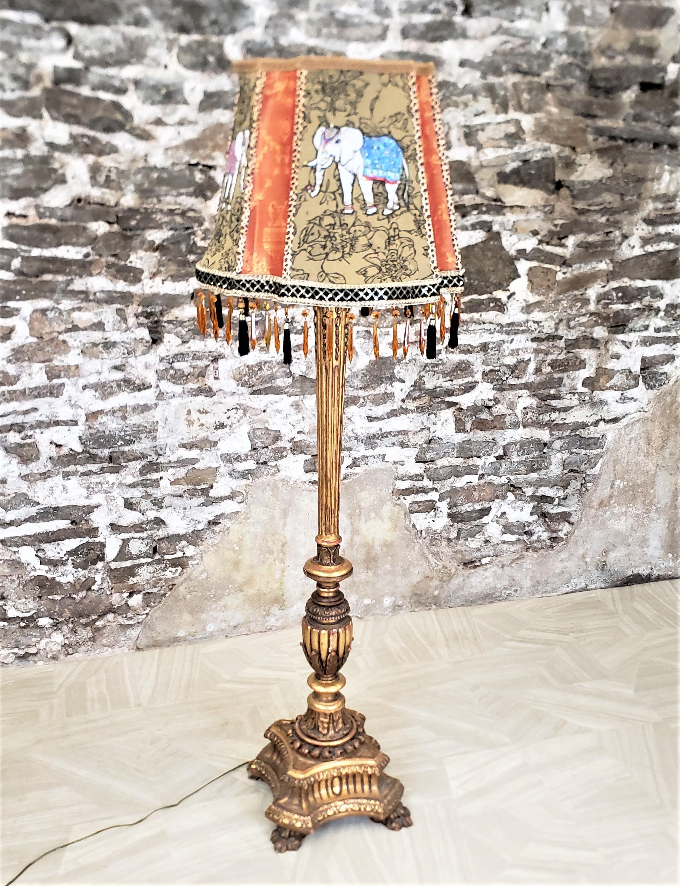This antique florr lamp is unsigned, but presumed to originate from Italy and date to approximately 1920 and done in a Classical Florentine style. The lamp base is composed of a softwood that have been heavily hand-carved with considerable