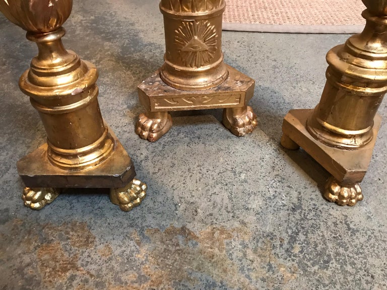 These antique Italian candlesticks are gilded in gold paint and come in a set of 3. The front of the candles have paws for feet. Two candlesticks are a matching height and the third is larger.