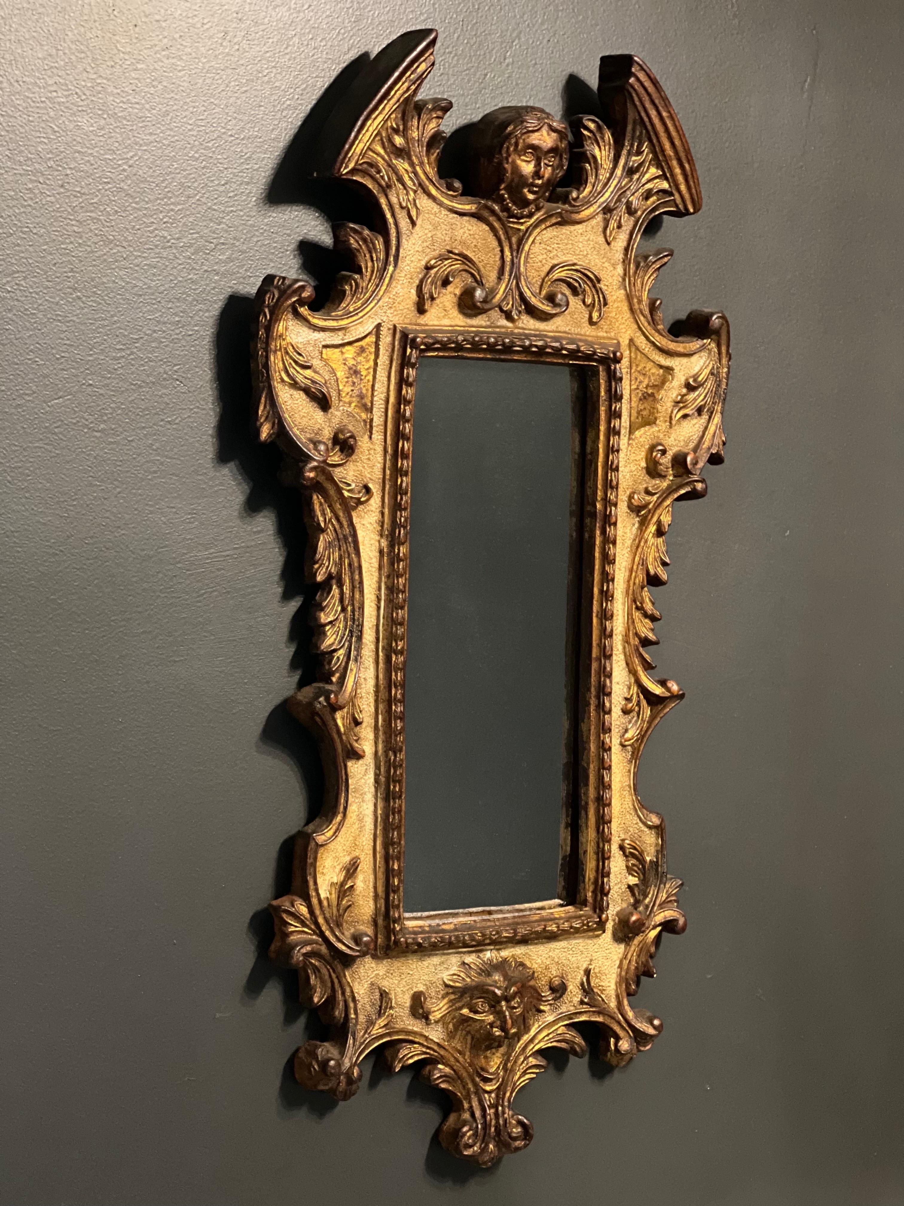 Exquisite antique Italian mirror, Italy, circa 1890's.

The mirror features a gilded wood and gesso frame with intricate carvings of a winged angel, a lion's head and elaborate scroll detail throughout. High quality mirror is in clean condition.