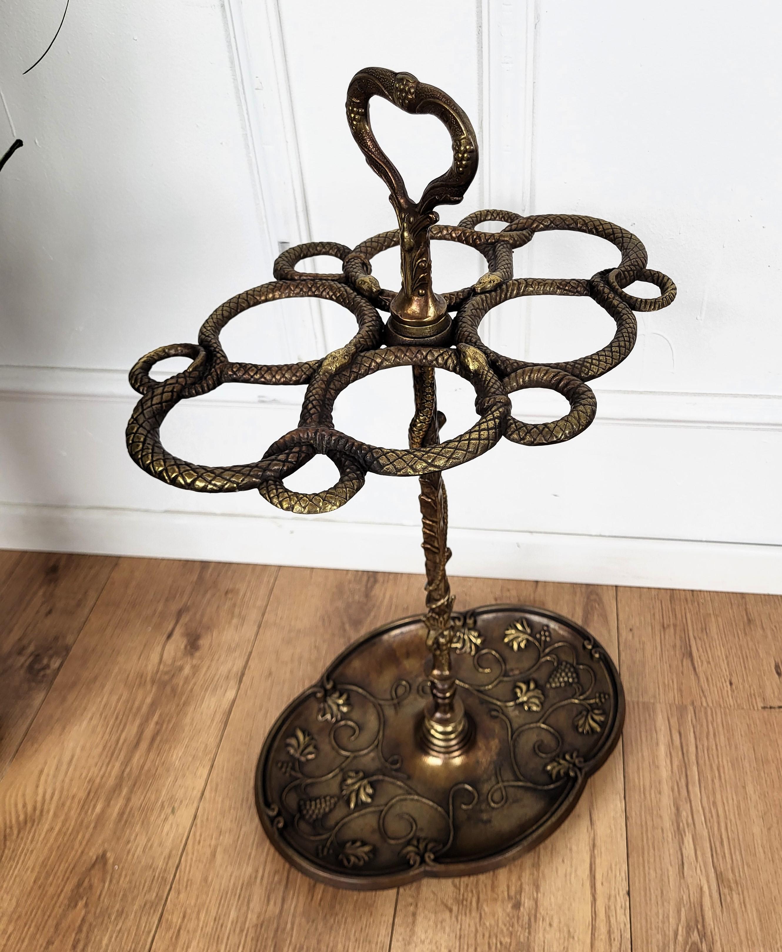 Beautiful and elegant golden cast iron umbrella stand. The top is decorated with four snakes and their heads, the central andles and stand are as well decorated and show two faces and several other fidures as does the bottom umbrella holder. Great