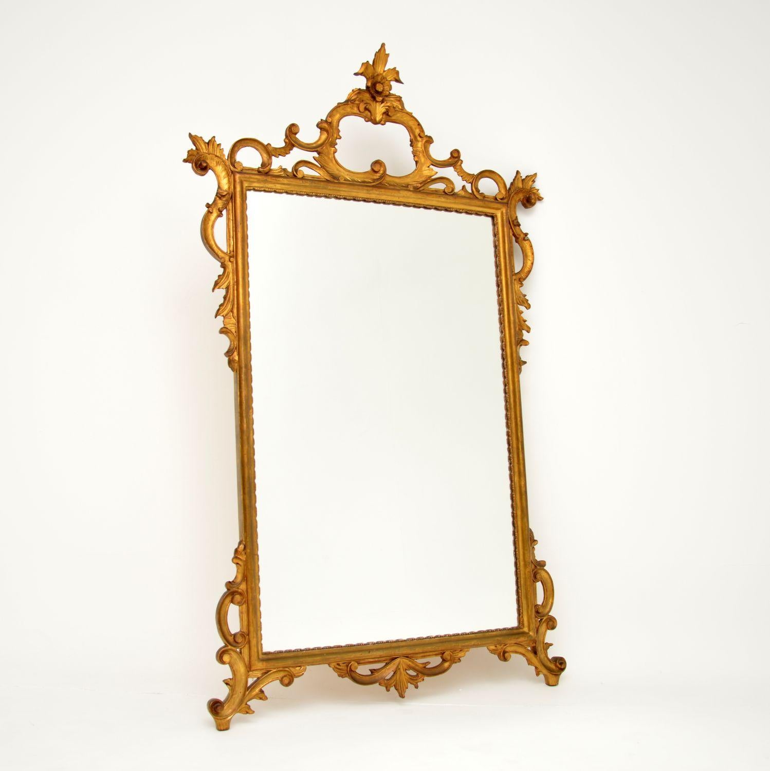 A beautiful and impressive large antique Italian gilt wood mirror. This was made in Italy and dates from around the 1950’s.

It is a fantastic size and is of amazing quality. The gilt wood has gorgeous carving in the rococo style, with scrolled,