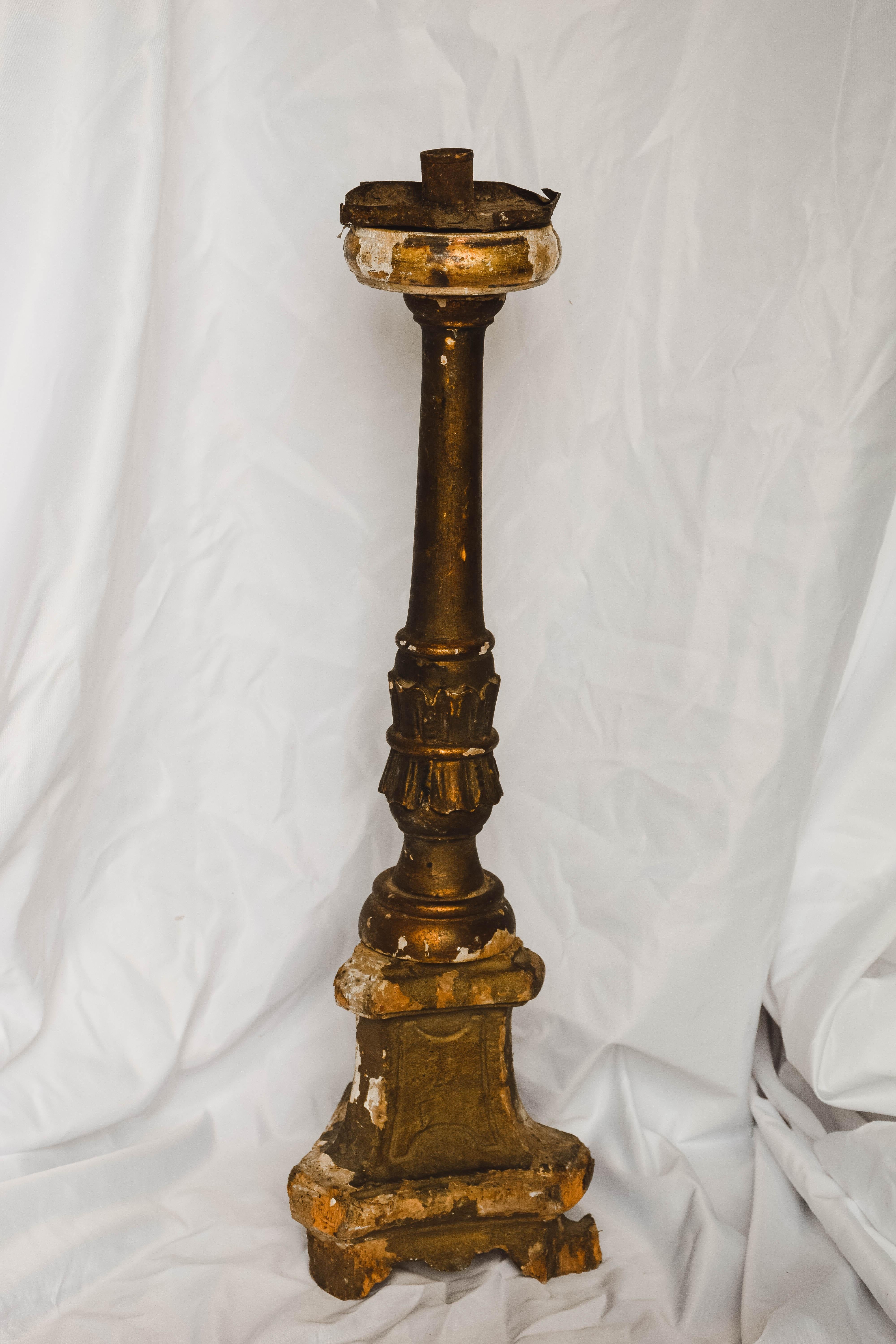 Italian late 18th-early 19th century gilded altarstick. This Italian altarstick features gilding on all sides, however it does show some wear. The central column is hand carved and is raised on a tripod base. The top of this altarstick is metal and