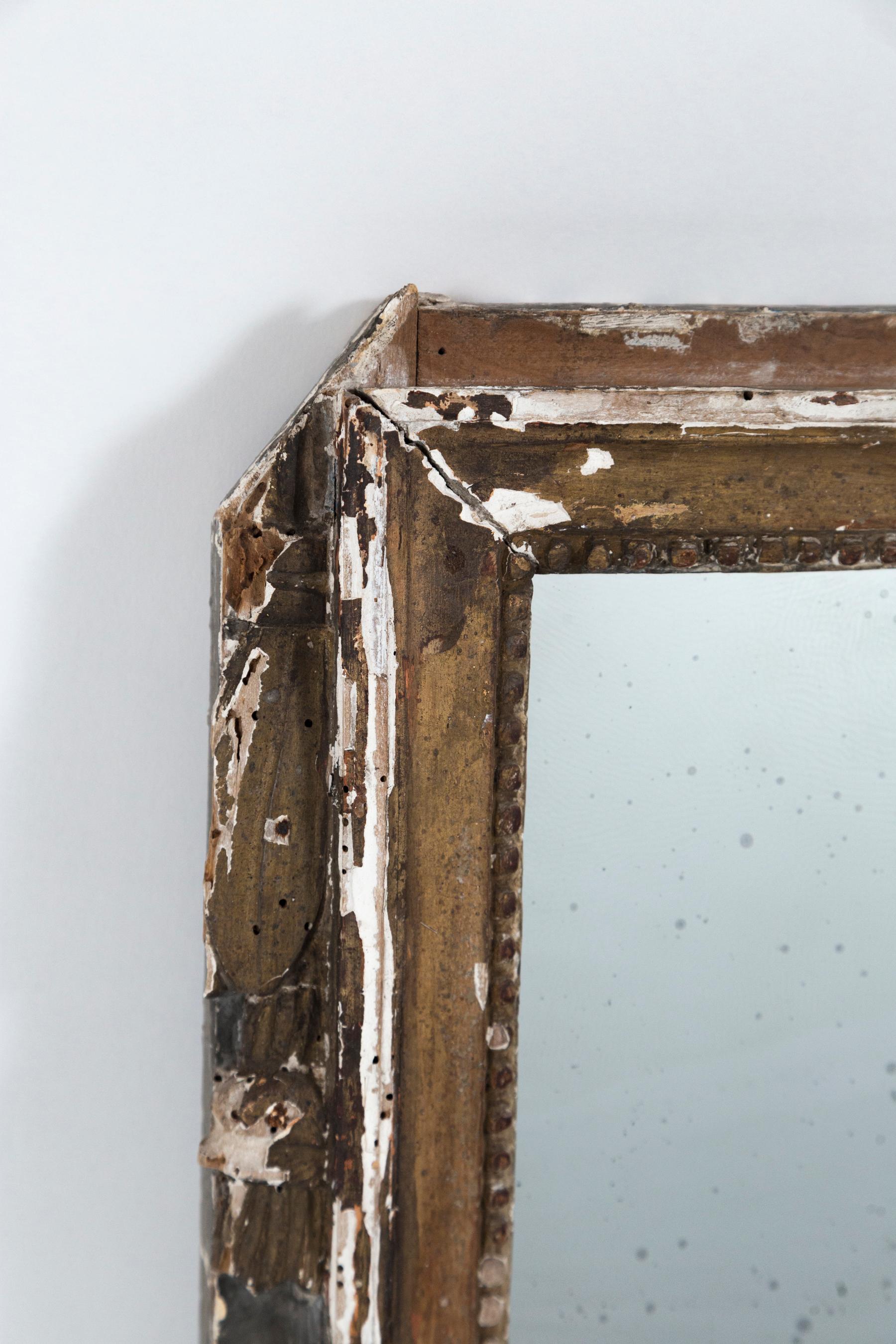 Cadre de miroir italien ancien en bois doré, fin du 18ème siècle. Surface vieillie avec dorure, peinture et plâtre d'origine. La surface est joliment endommagée, mais structurellement stable. Nouveau verre 