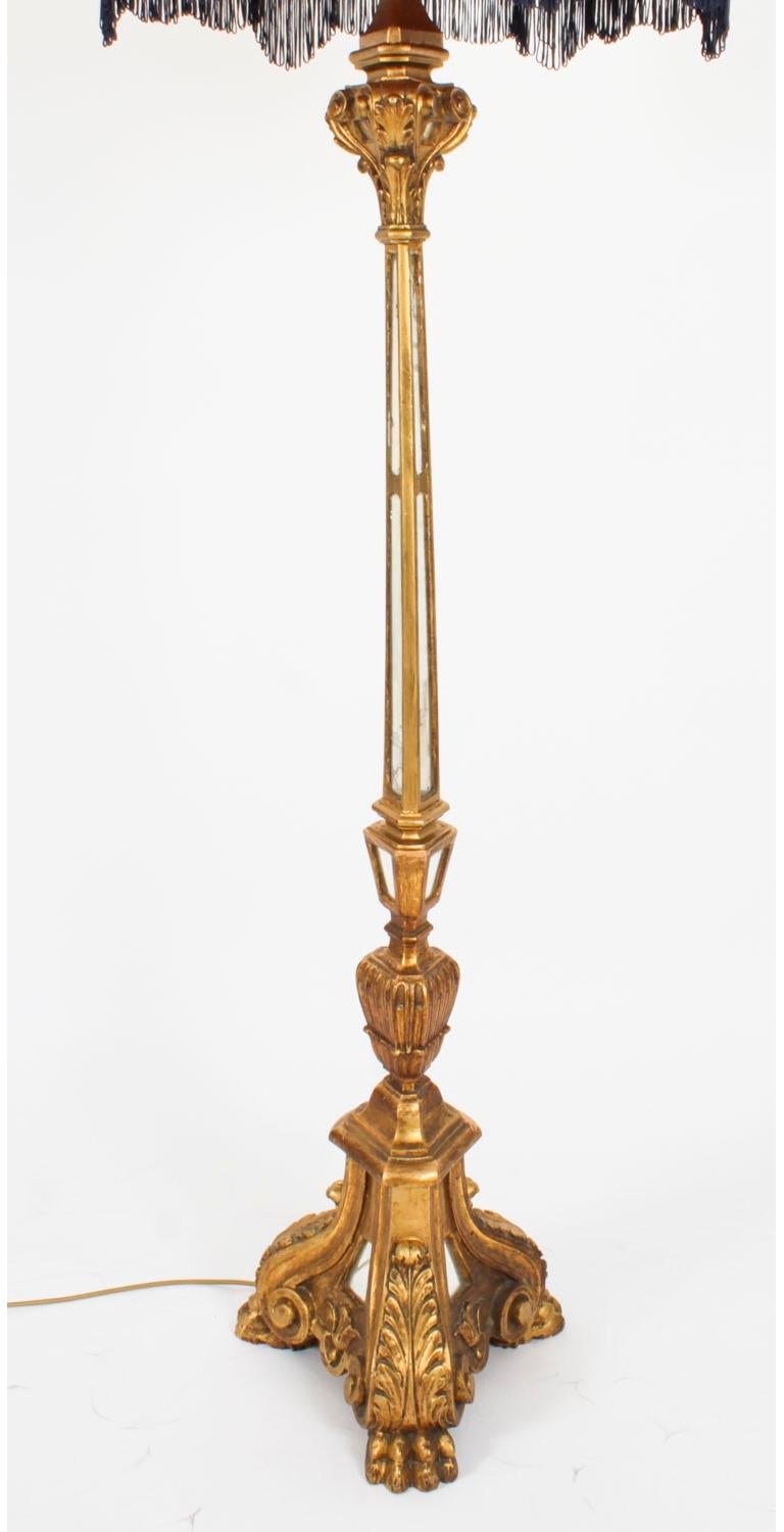 This is a highly attractive antique Italian Renaissannce Revival giltwood Torchere standard lamp, fitted with a peach and nave shade, now converted to a standard lamp, circa 1890 in date.

This splendid lamp features a distinguished triangular