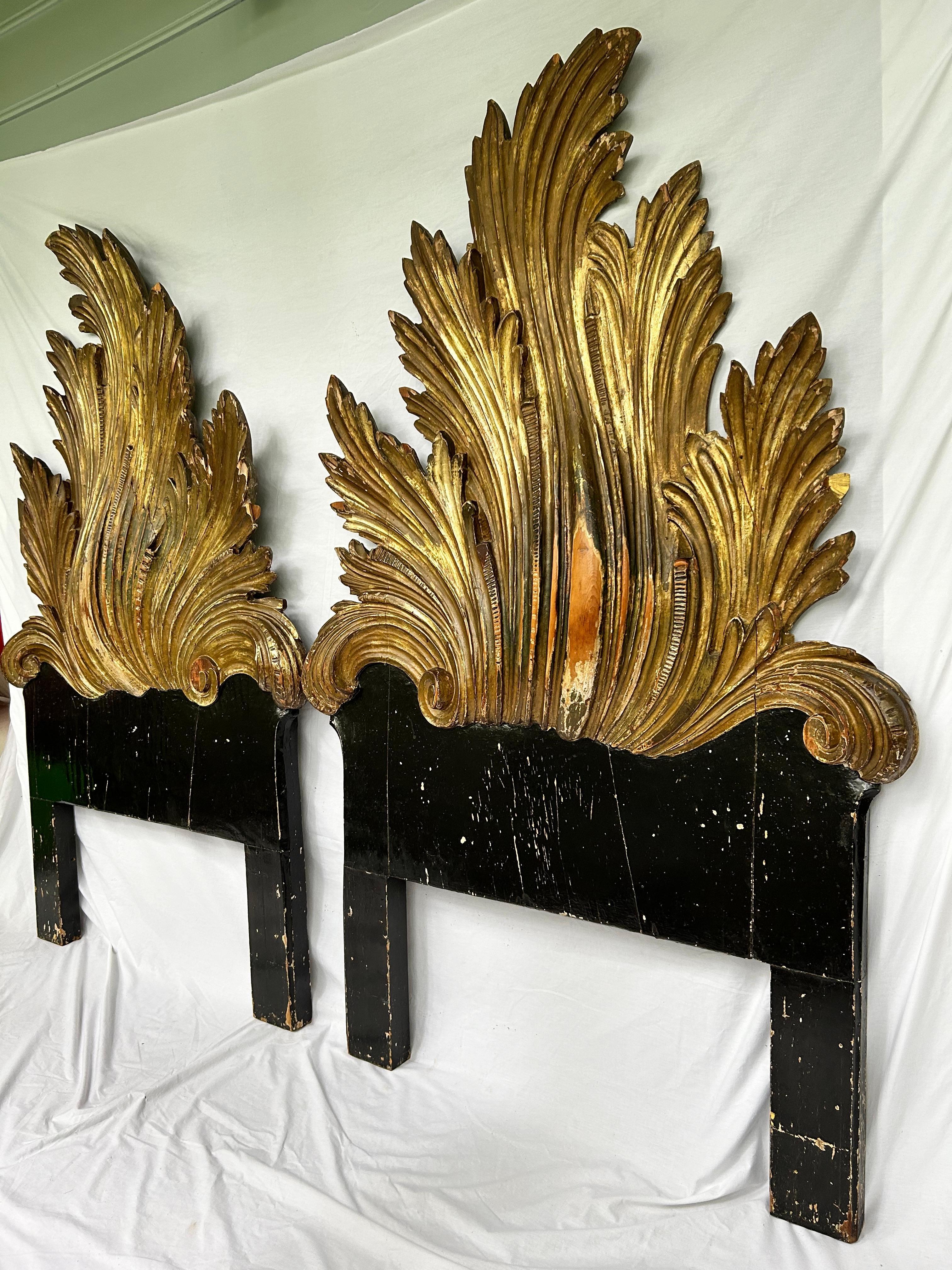 A spectacular pair of antique Italian headboards, hand carved and gold leafed (parcel gilt as the backs are not gold leafed and the integrated supports are painted black), from the ex-collection of New York City fashion designer, Chanel model,