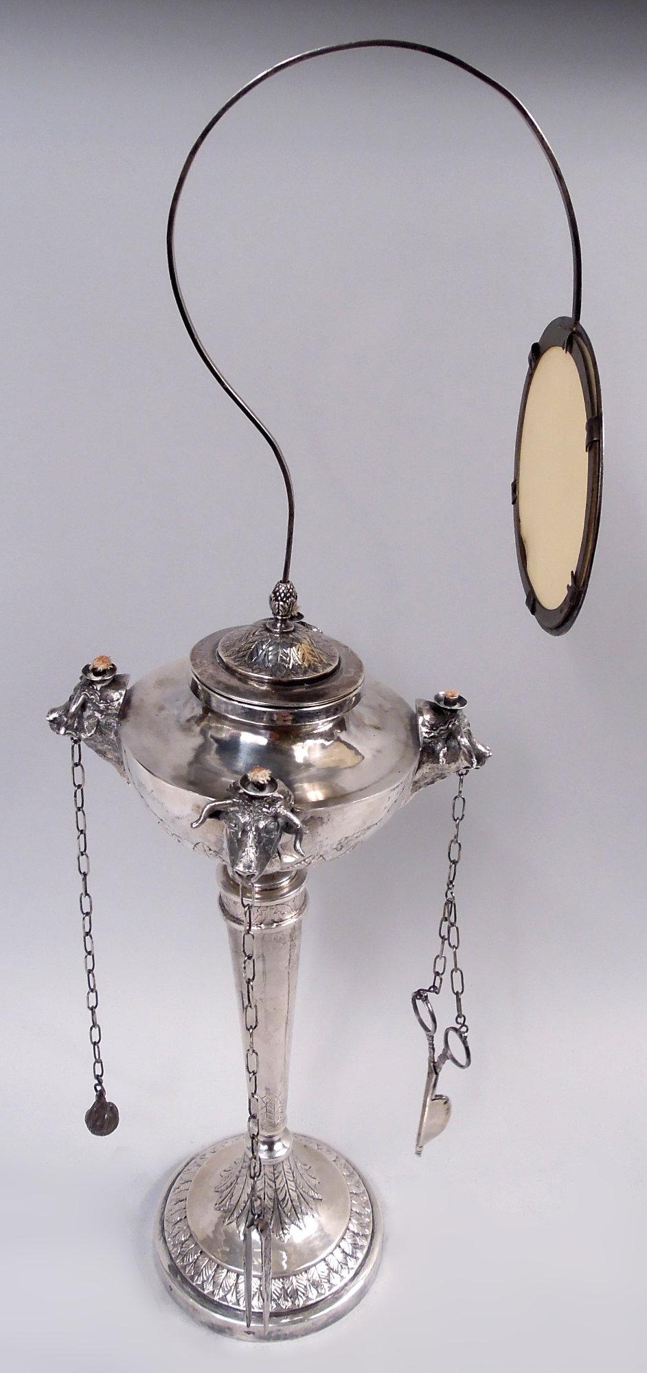 Lampe à huile en argent néoclassique italienne de l'époque du Grand Tour, vers 1830. Cuve hémisphérique montée avec quatre brûleurs à tête de taureau en fonte, chacun avec un outil à chaîne. Couvercle bombé ; abat-jour sur un support à volutes serti