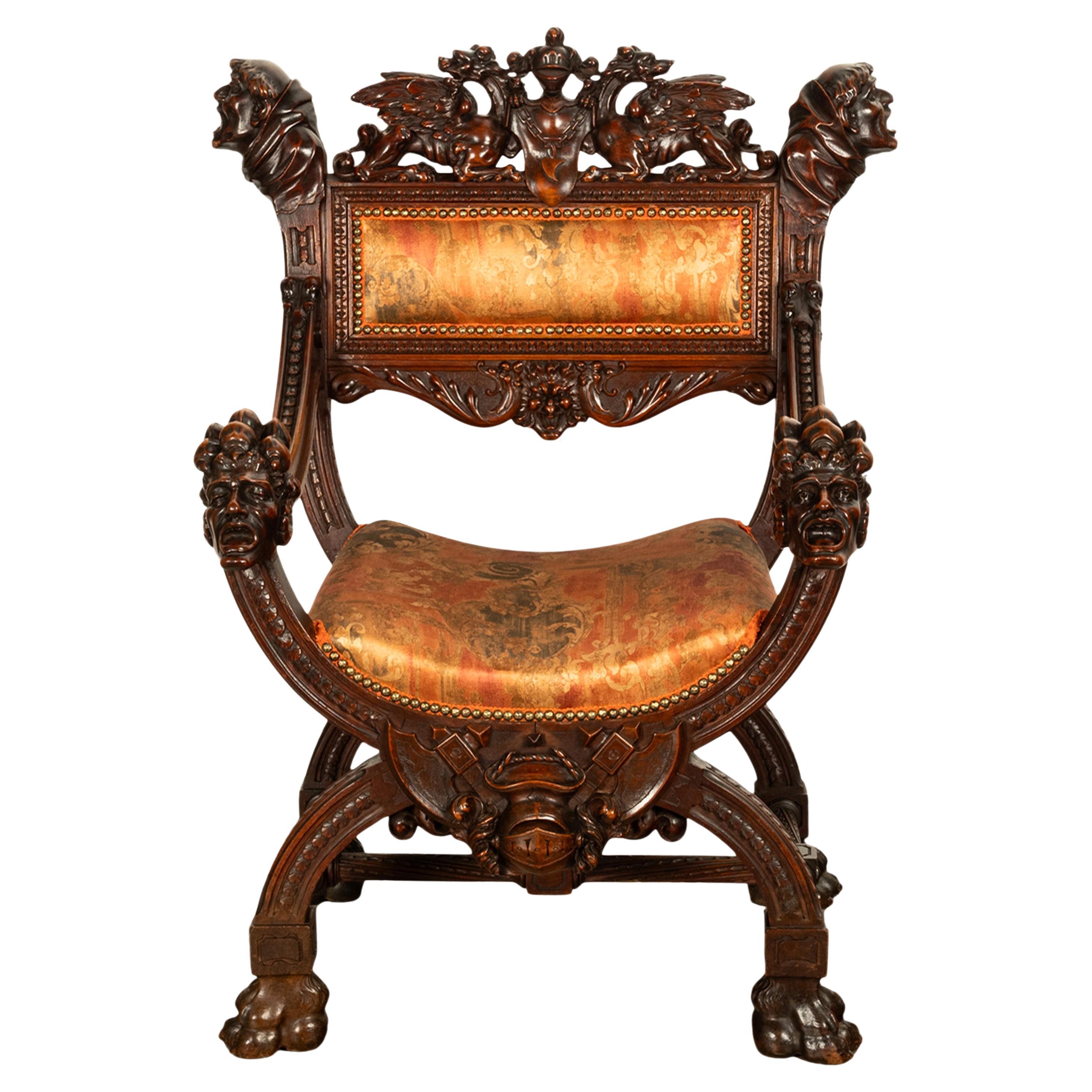 A fine & remarkable carved walnut Renaissance Revival Italian Curule chair, carved with Dragons & Knights, circa 1880.
The chair having a very finely carved top crest with a pair of winged dragons with their claws resting on a shield draped with a