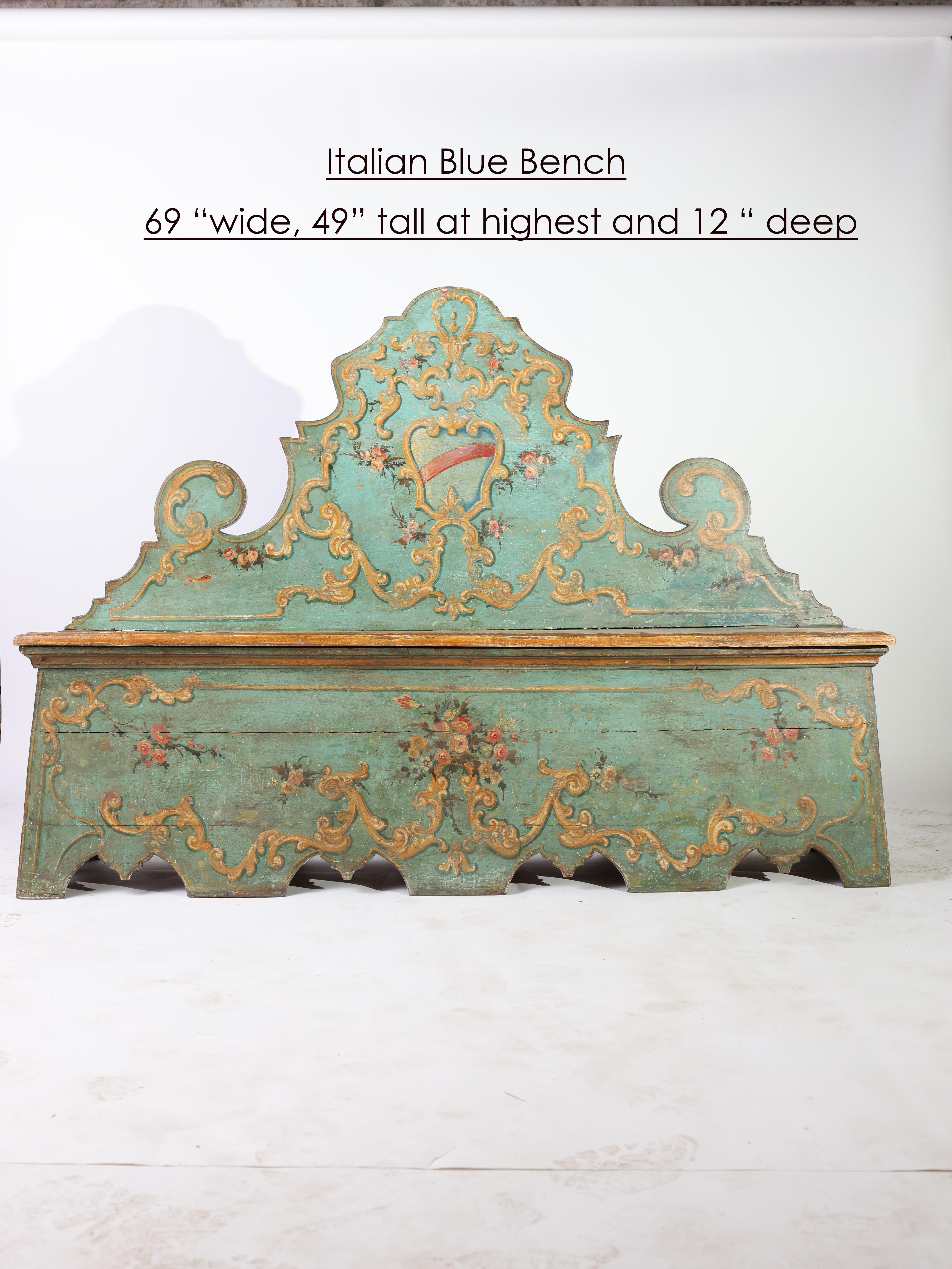 The incredible hand painted floral details on this stunning Italian bench make it a breathtaking piece of art. Carved gilt embellishments adorn the vibrant blue bench with a crest cartouche at center. 

This remarkable I8th century Italian piece