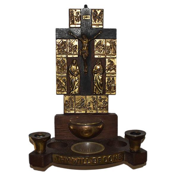A gorgeous antique Italian holy water font created from wood and brass. The back of the font features brass decorations depicting the stations of the cross. At the center, Christ's crucified body is affixed also in brass. 

A brass holy water bowl