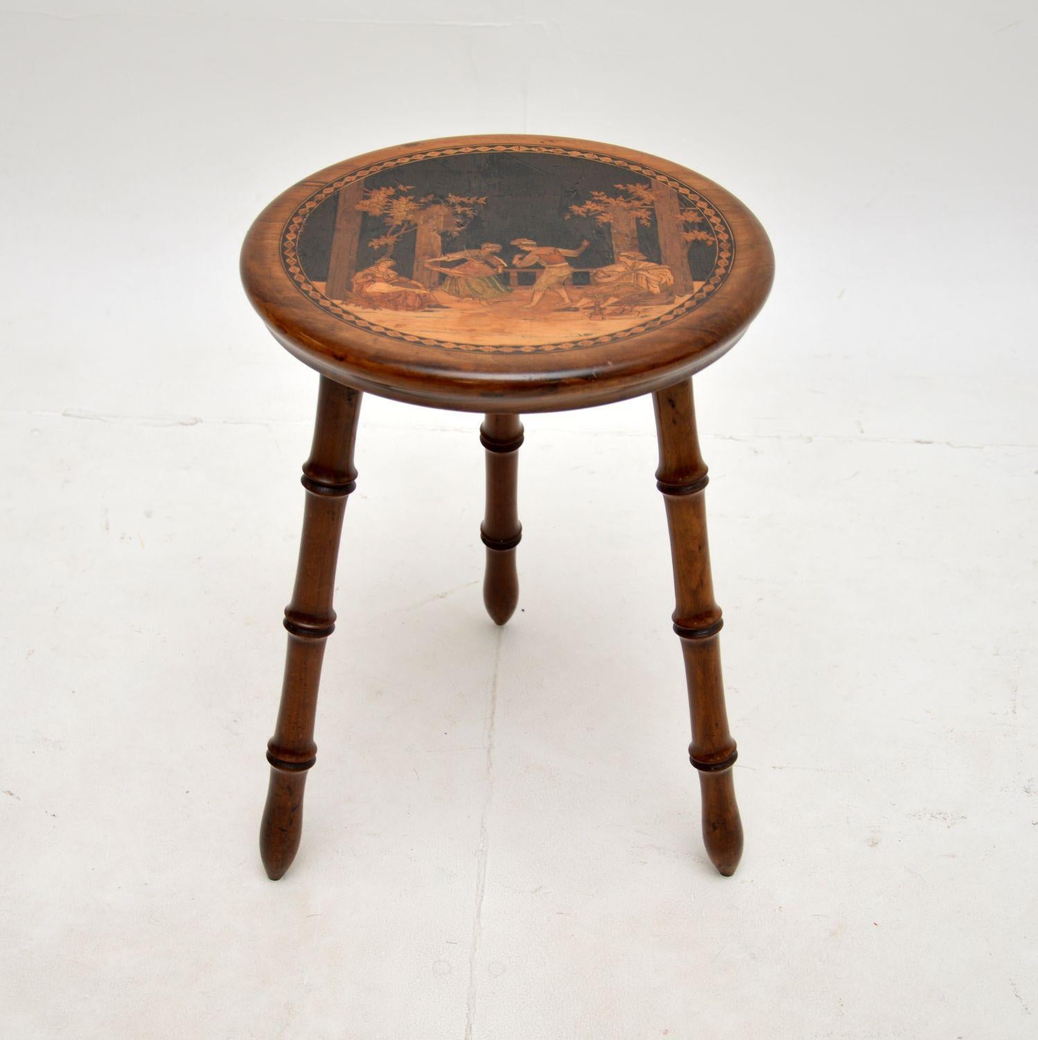 A beautiful antique Italian inlaid olive wood stool. This was made in Sorrento, Italy, it dates from around the 1900-1910 period.

It is of superb quality, with absolutely gorgeous inlays depicting an Italian classical scene. The three legs are
