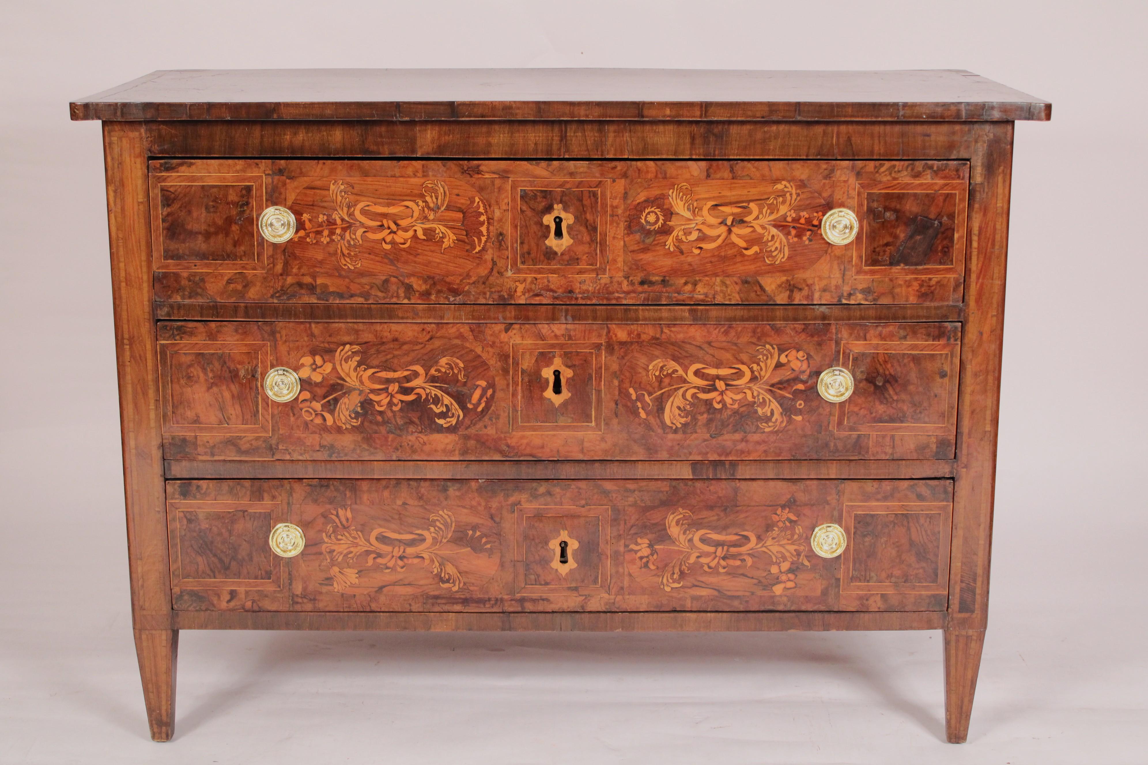 Antica cassettiera in noce intarsiata in stile Luigi XVI, XIX secolo. Con un piano rettangolare con intarsio floreale, sotto ci sono 3 cassetti con ferramenta in ottone e intarsio floreale, lati con intarsio floreale e poggia su piedi affusolati