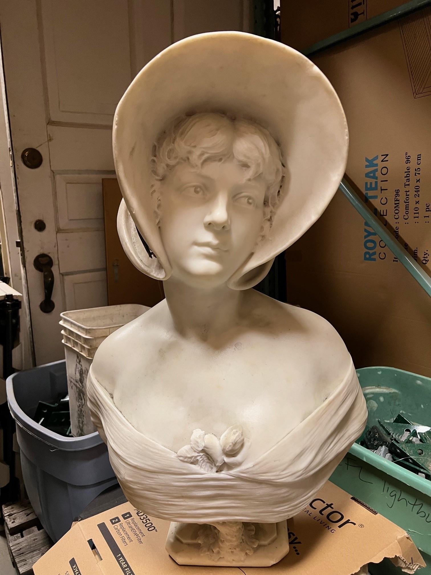 A fabulous hand carved antique Italian Carrara marble bust of a beautiful woman with a bonnet. This bust is of very good quality and craftsmanship, her face and hair are  beautifully hand carved under a large bonnet. The bonnet has a ribbon made of