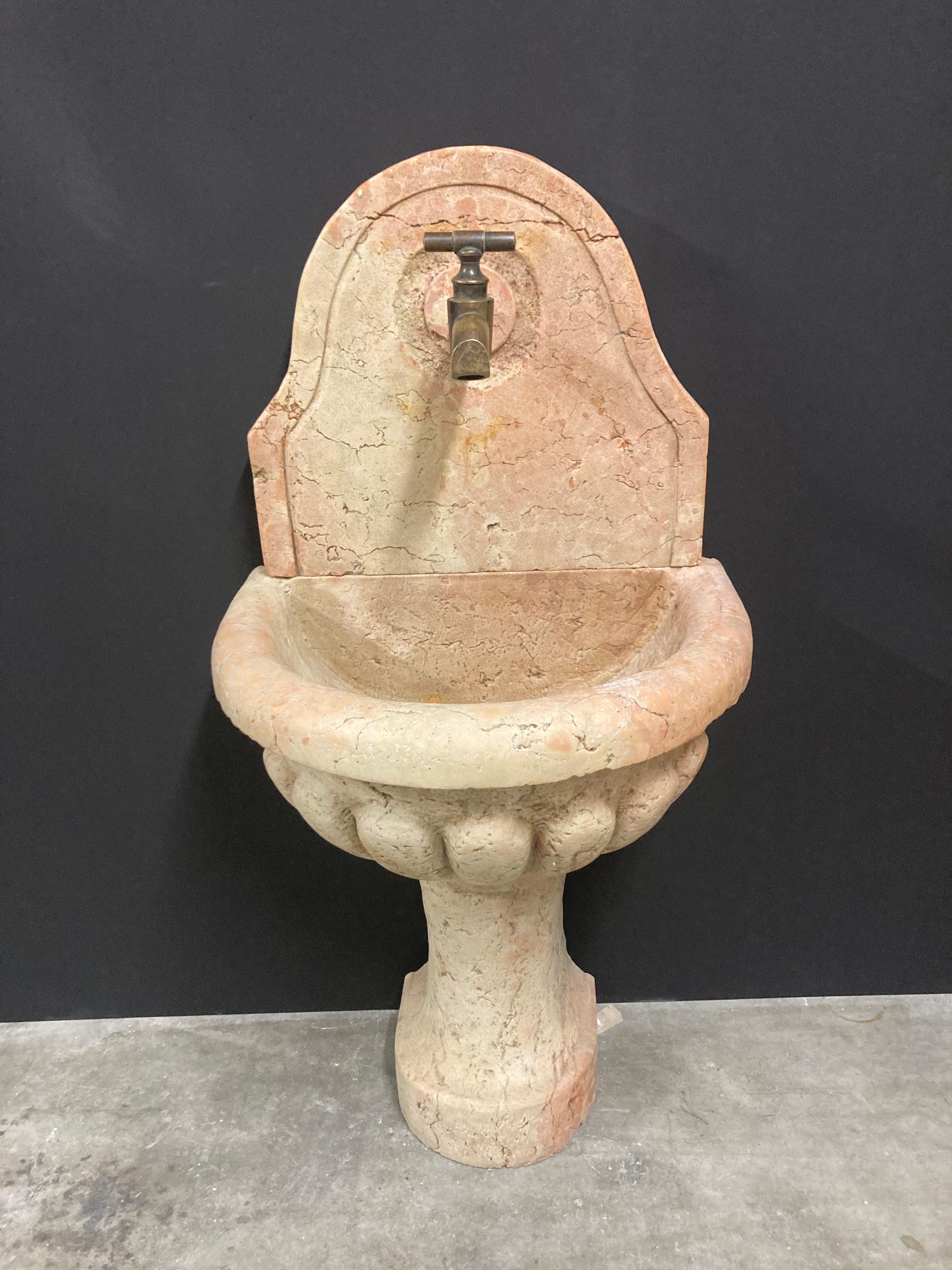 Happy to offer this antique Italian beautifully carved wall fountain or powder room sink.
This fountain dated from the 19th century and is made from marble quarried in Verrone, Piedmont, Italy. 

The marble’s color is mainly an ochre/tan color.