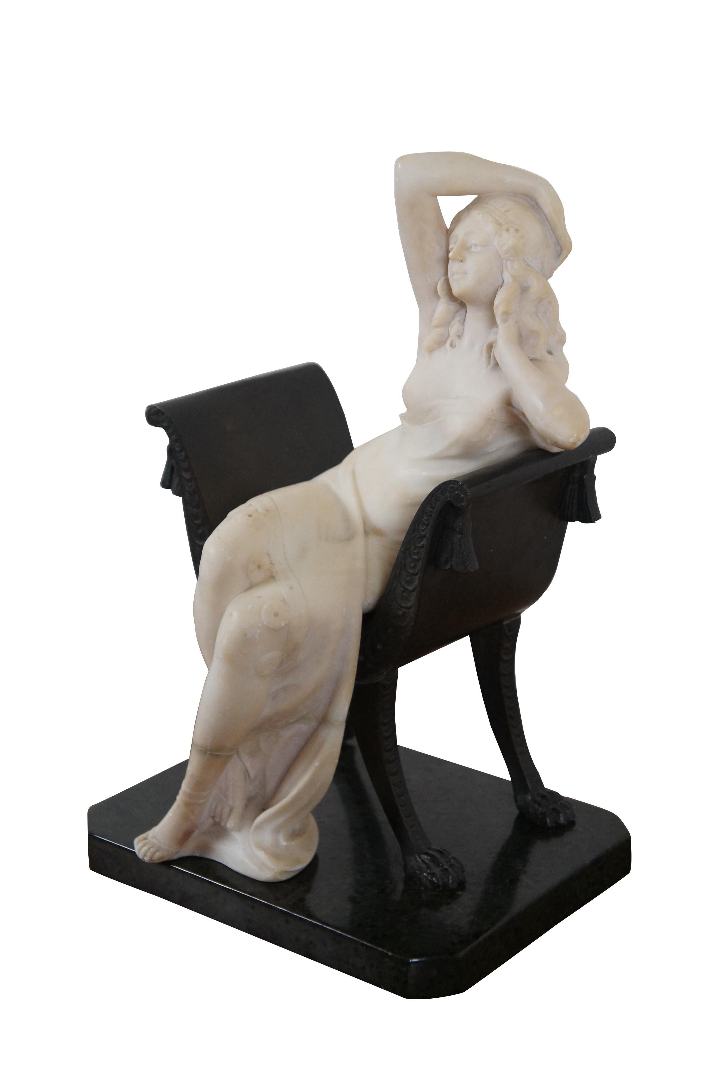 Late 19th - early 20th century carved marble sculpture in the shape of a Neoclassical woman seated in a bronze Savonarola style chair, mounted on a slab of green and black marble. Surface of plinth marked Italy. After Antonio Frilli and Emilio