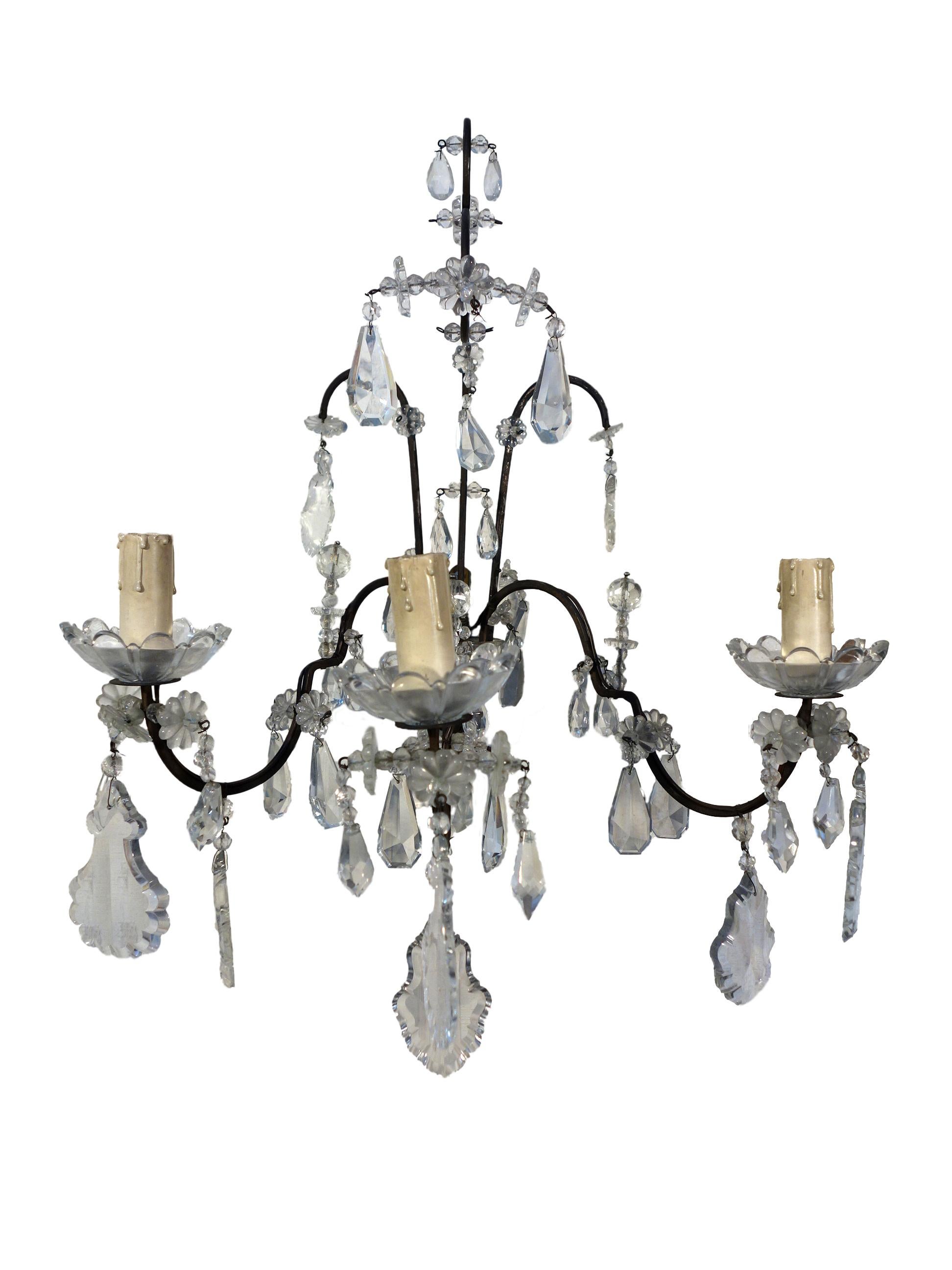 Antique Italian Maria Theresa Baroque style pair of delicate Venetian sconces with 3 candles on glass cups, burnished gold metal fixture, and cut glass pendants and beaded swags, circa 1910. Beautiful detailing and light reflecting glass pieces add