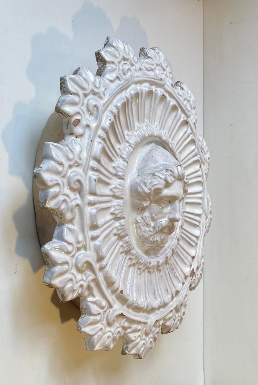 Ornamentale Wandmedaille aus gebrannter Terrakotta. Die gesamte Front ist mit der ursprünglichen weißen Glasur überzogen. Sie wurde auf Bestellung in Italien um 1850-1880 hergestellt. Geeignet als Wanddekoration im Badezimmer, in der Orangerie, im