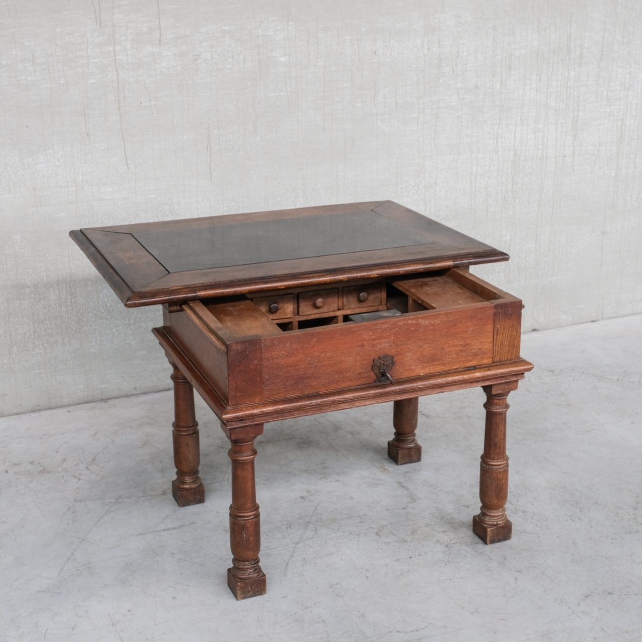An 17-18th century antique desk. 

Likely Italian, but sourced in France. 

Solid oak with a marble inset top. 

An exceptional table with crafty hidden sliding storage, accessed by a thick high quality decorative key, which is matched by the