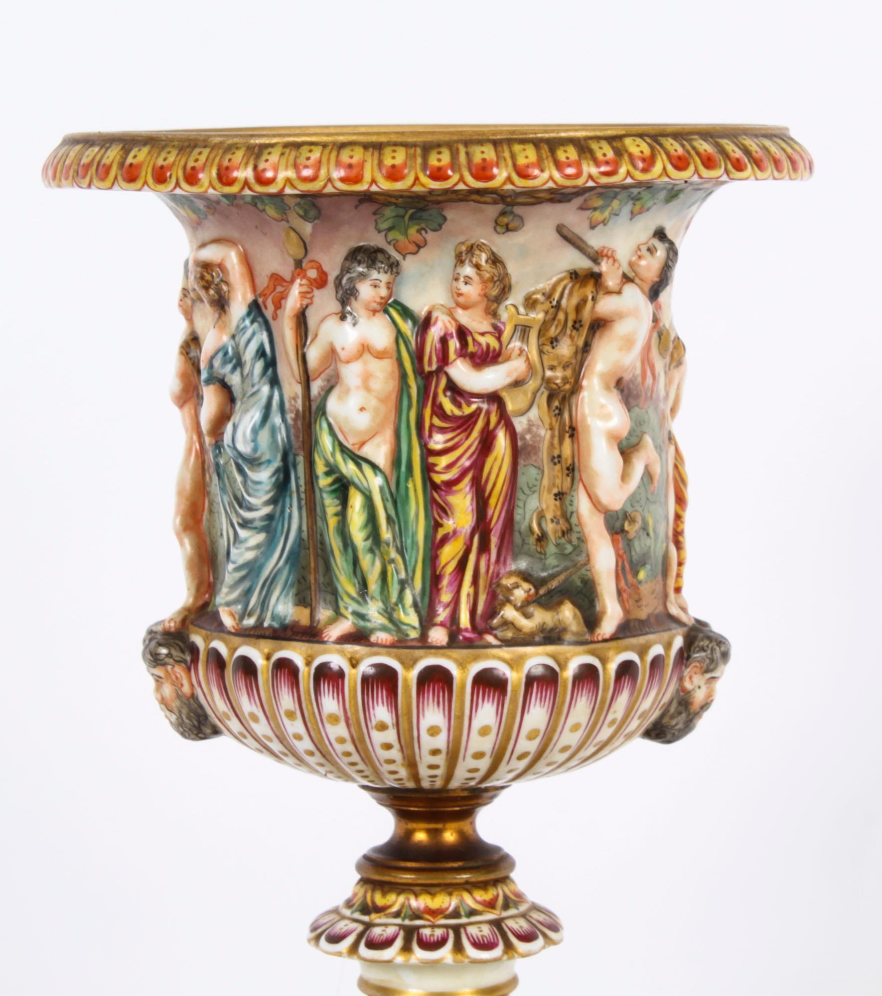 This is a beautiful antique Italian Naples Capodimonte porcelain  urn, late 19th Century in date and bearing the Naples Capodimonte blue painted crown signature on the underside.

Superbly decorated with polychrome enamels  in relief with classical