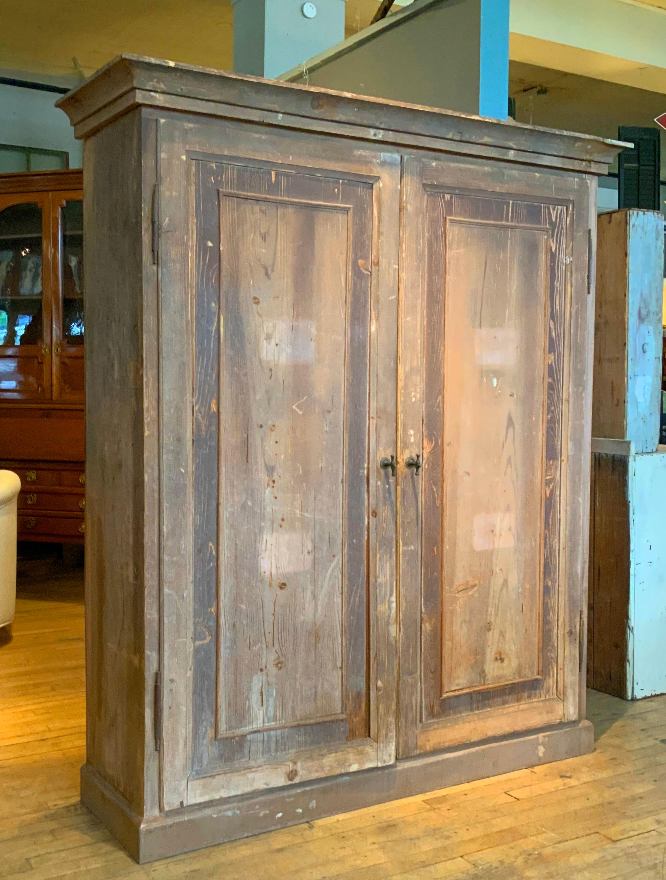 A beautiful Italian natural wood two door cabinet, with divided interior and original hardware. beautiful weathered finish and patina, with crown molding capitals. Wonderful scale and details, and great proportions. Perfect for a wide variety of