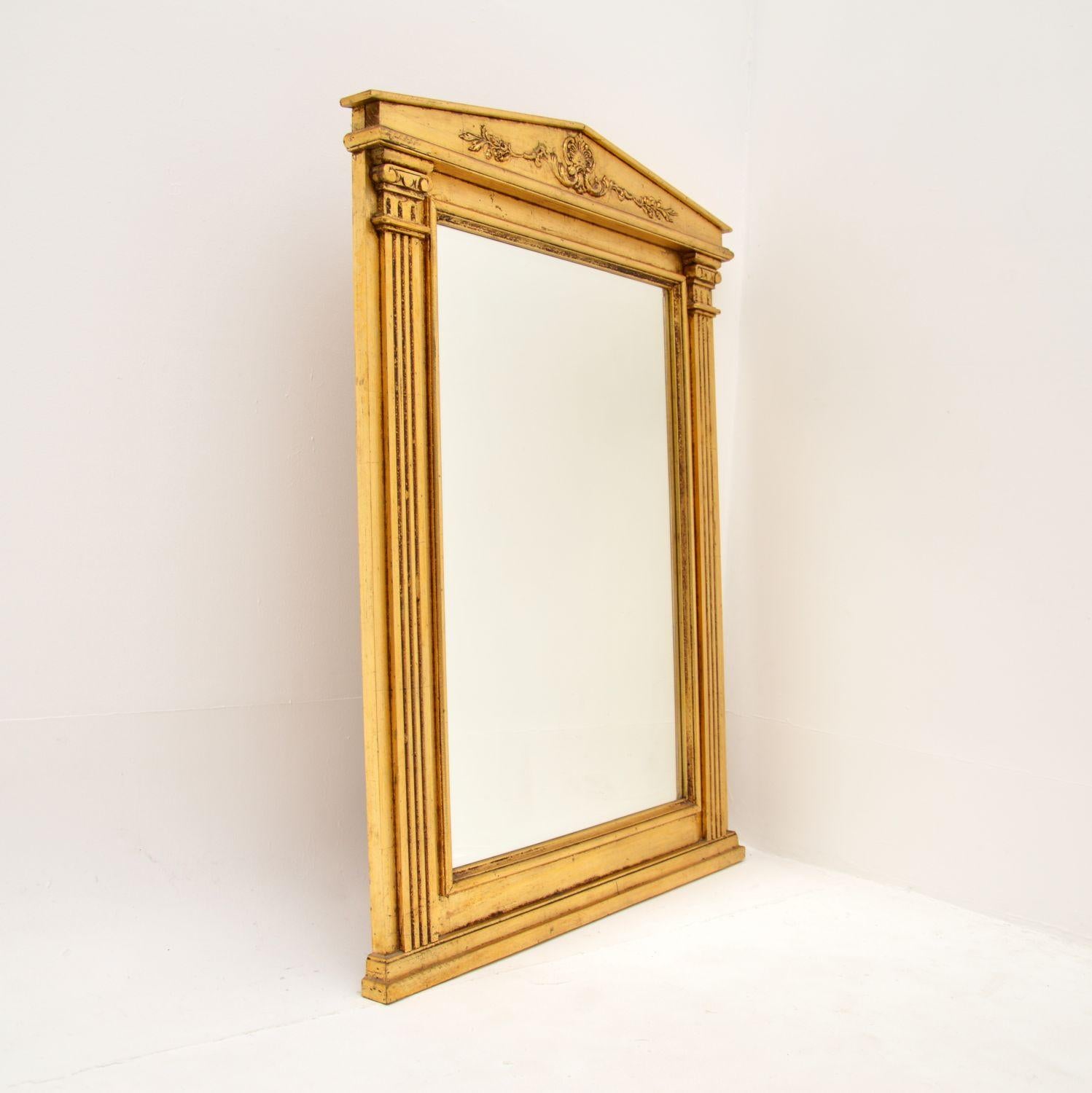 Magnifique miroir italien néoclassique en bois doré. Fabriqué en Italie, il date des années 1930-50.

Il est d'une superbe qualité et d'une grande taille, assez large et impressionnant avec son verre biseauté. Les côtés sont ornés de colonnes