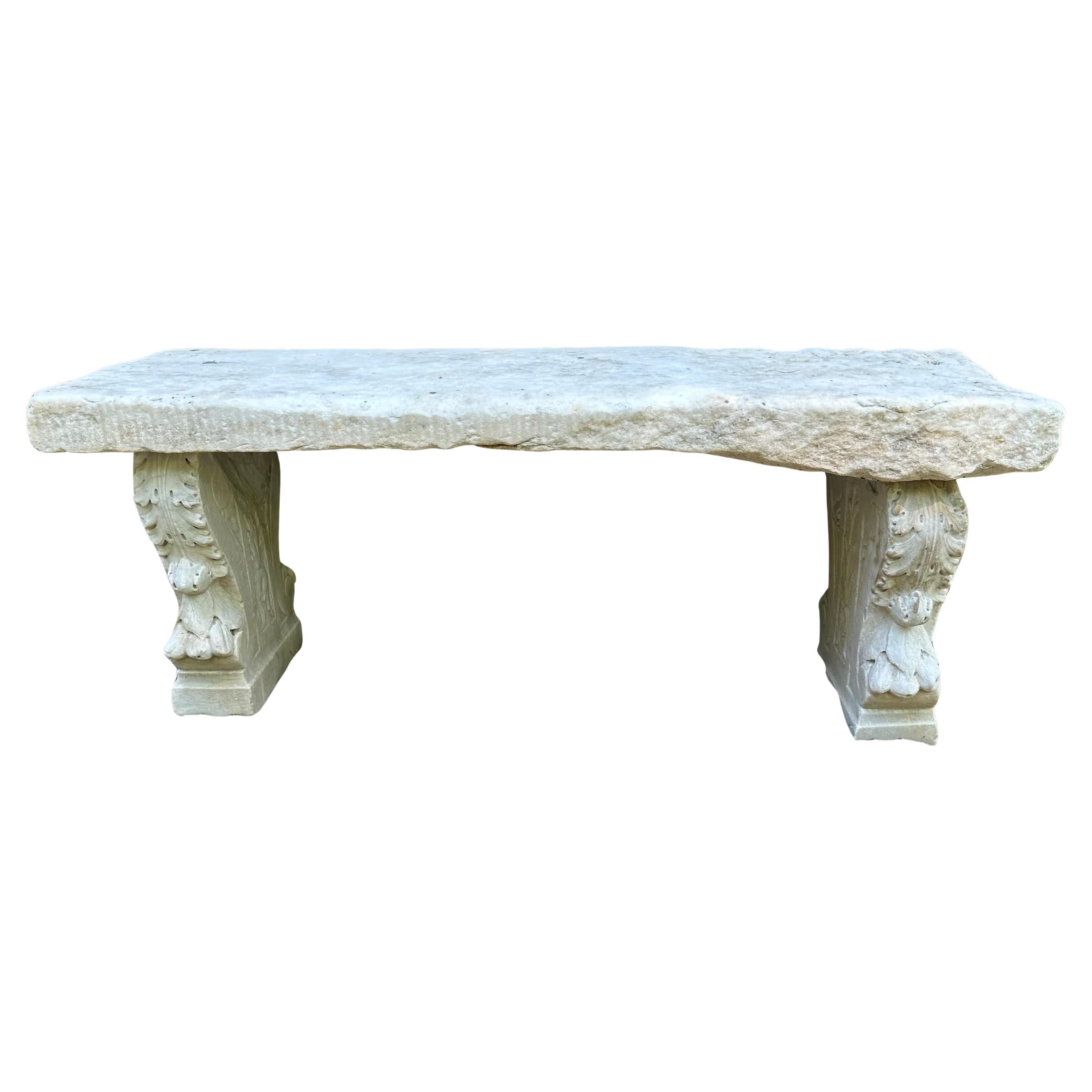 A handsome marriage of antique 18th Century Marble slab and a pair of carved 19th Century marble Italian Neo-Classical style stone plinth supports makes this a most charming and inviting garden bench.  The plinths display acanthus design,
