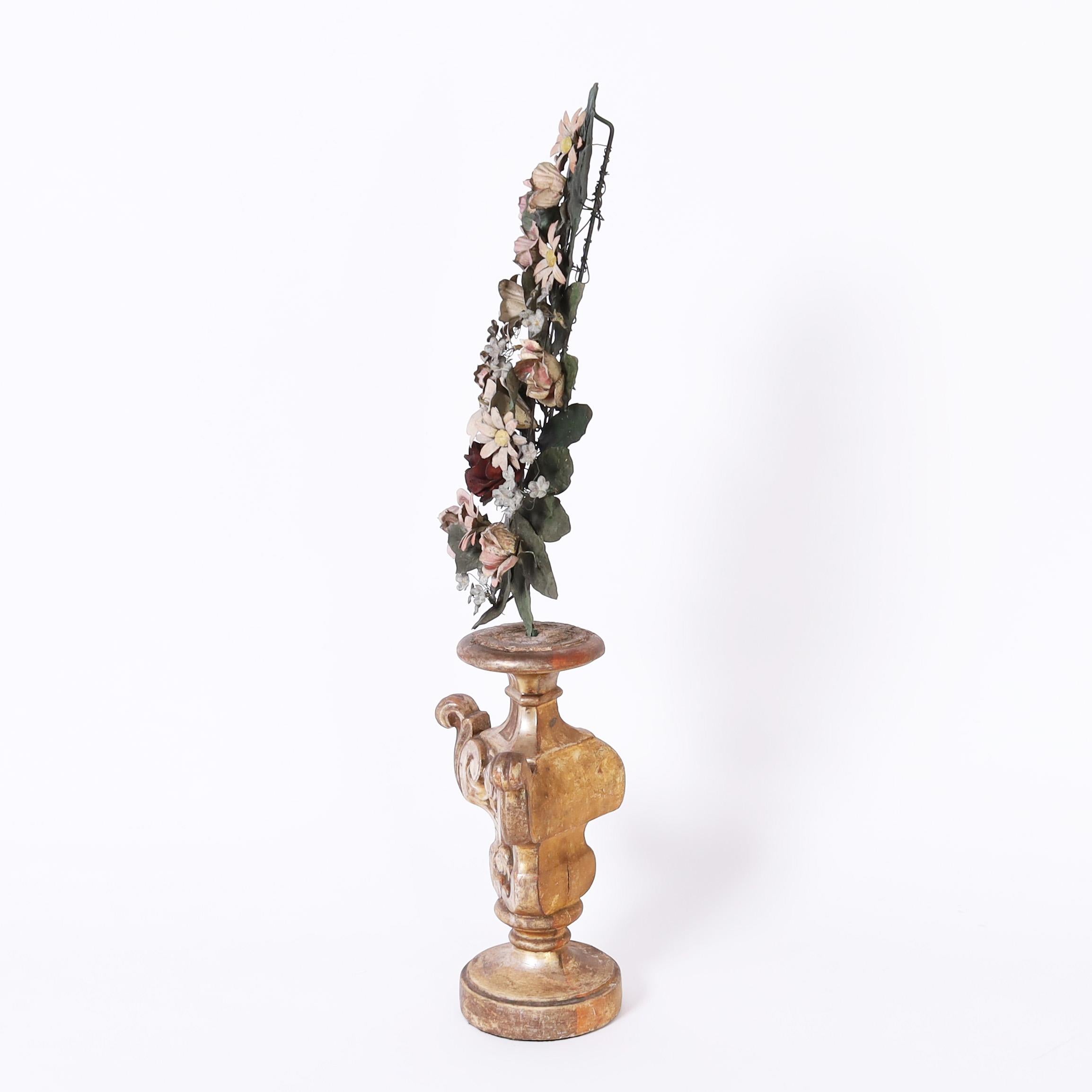 19th Century Italian carved wood remnant with classical form and a worn silver leaf finish holding a tole bouquet with flowers and leaves with a perfect time worn patina.