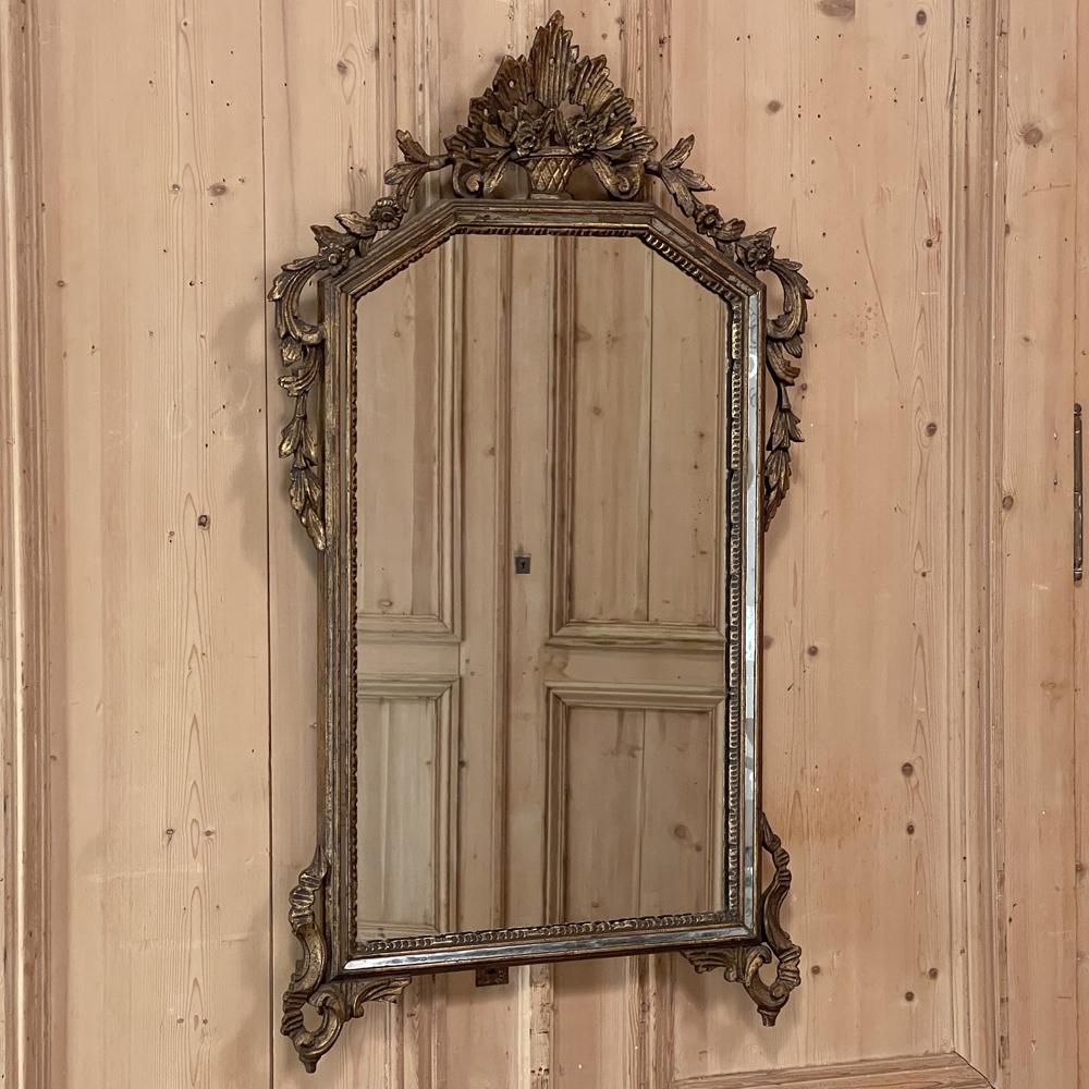 Antique Italian Neoclassical Louis XVI painted mirror is perfect for adding timeless style to any setting! The angled arched crown is festooned with carved flower basket and foliate motifs in a stylized expression, with cascading foliates leading