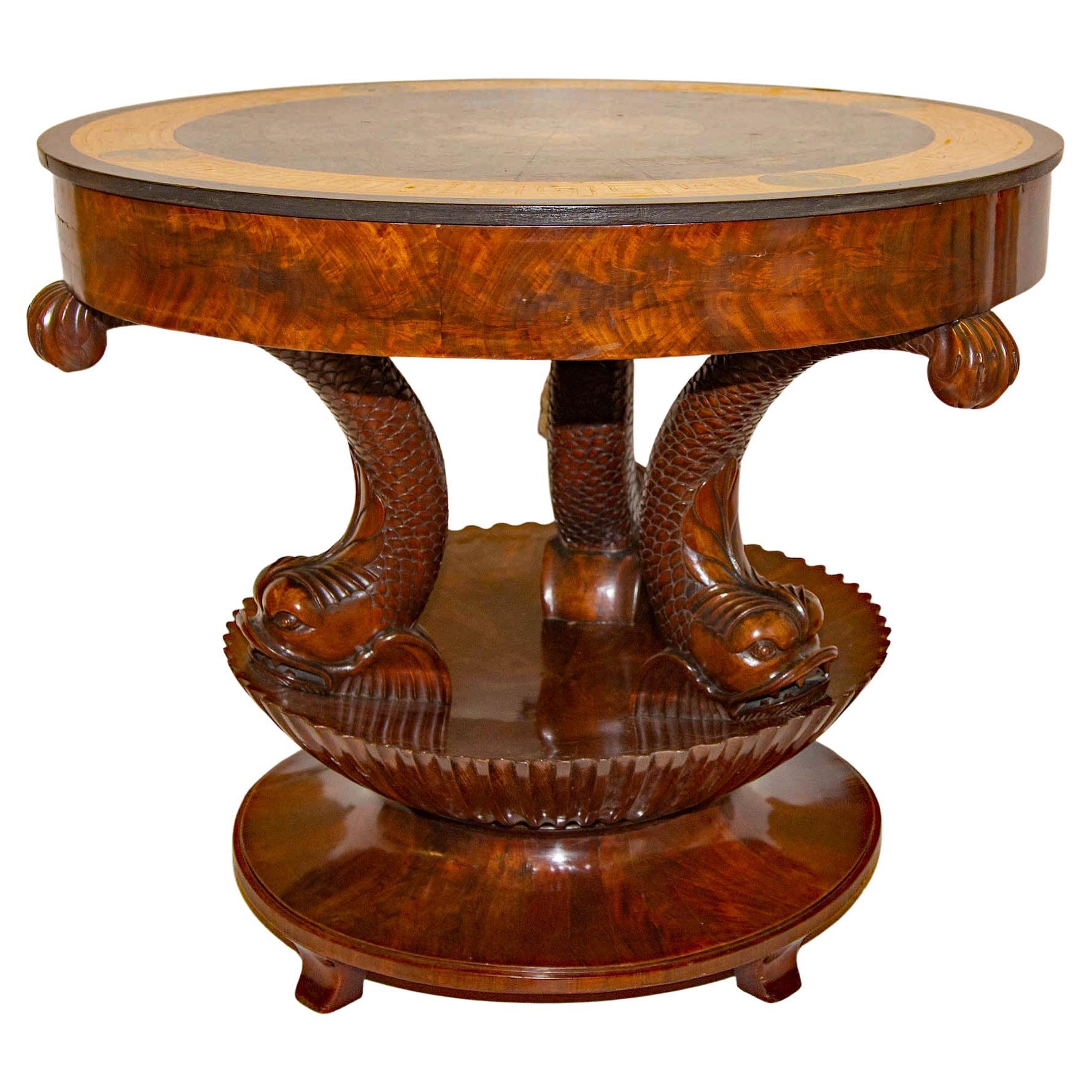 This Italian neoclassical center table is an absolute beauty. The scaglioa top is decorated with an abstract view of the heavens with rich blue colors. The base with carved dolphins rising from a shell form support. Made of fine Honduran crotch