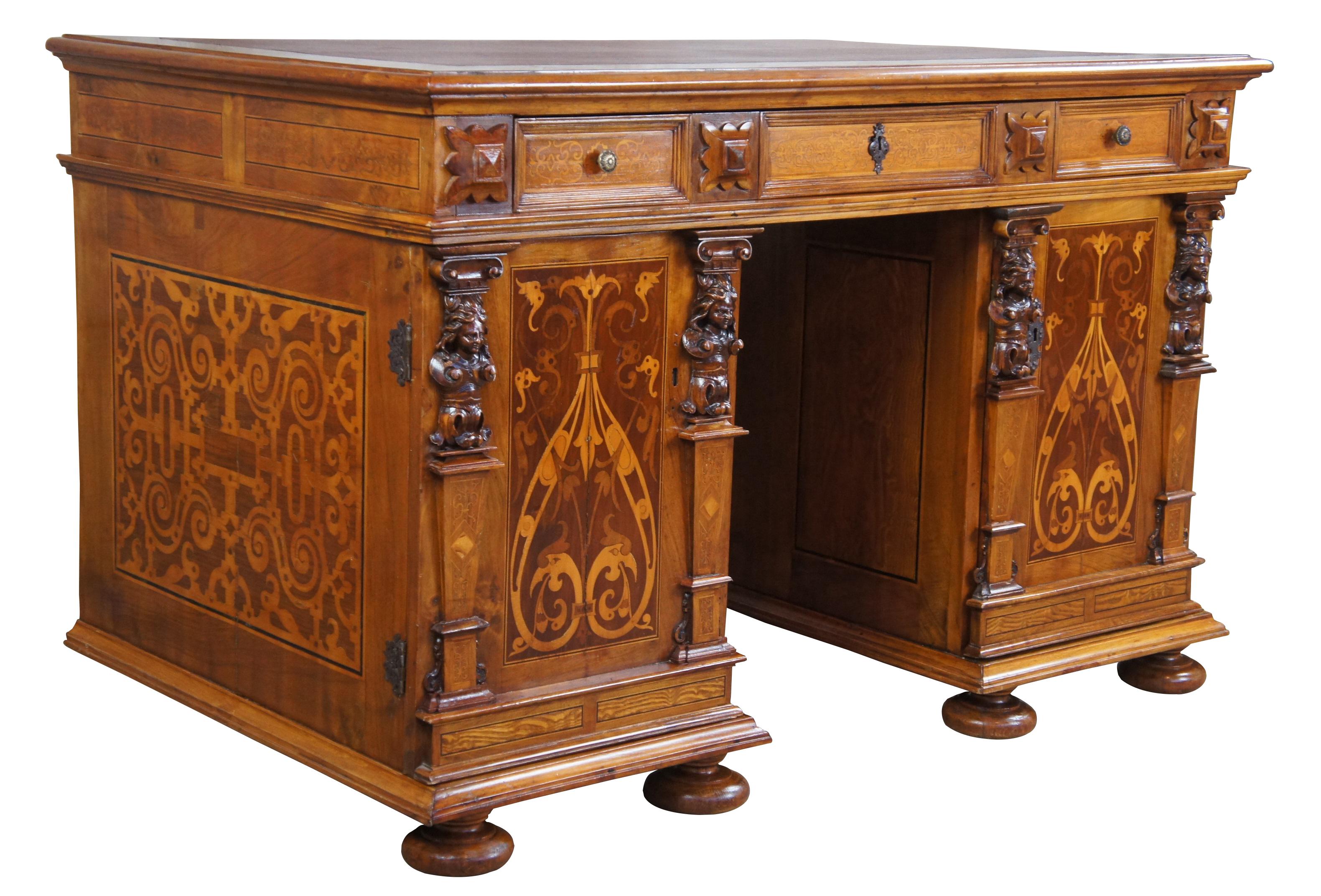 Antique Italian marquetry writing or library desk, Made from walnut with carved inlays of oak and fruitwood, circa 1900s. Features an inset leather top over a long frieze drawer on two figural carved pedestals enclosing three drawers each, on a