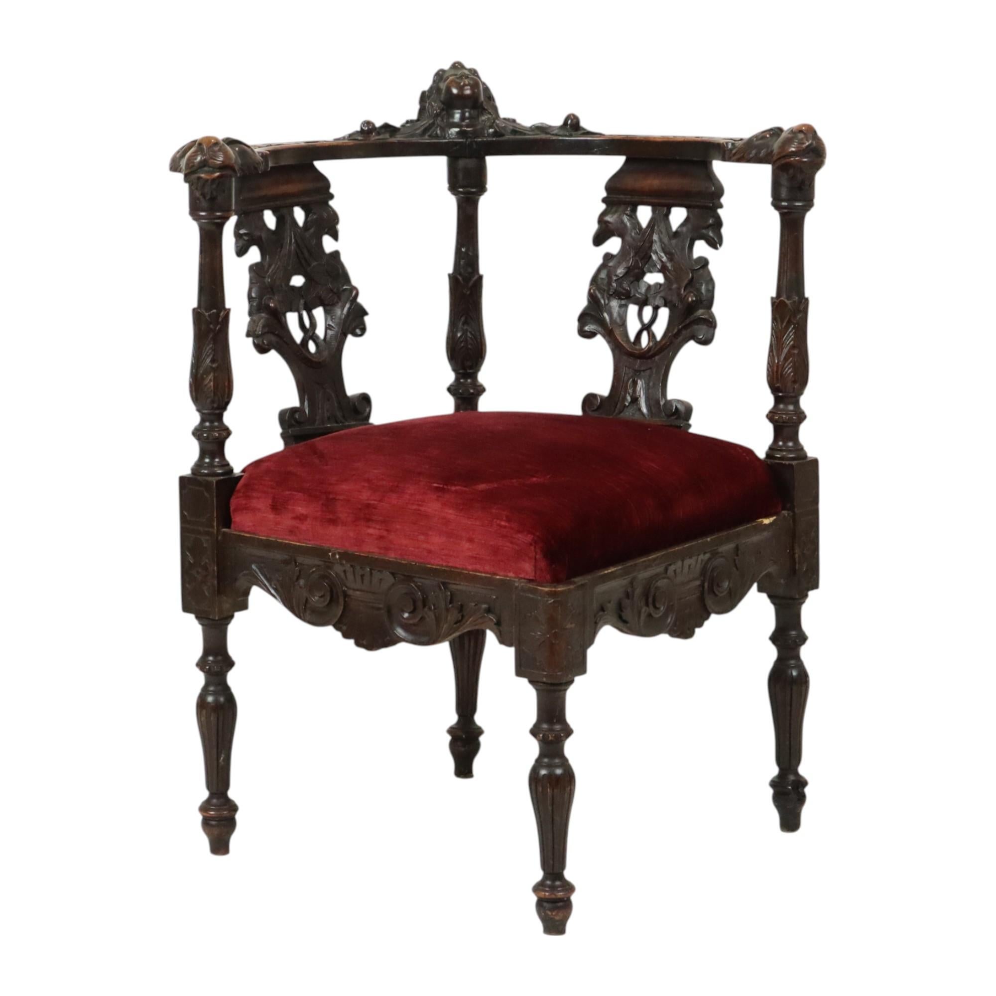Chaise d'angle ancienne en chêne sculpté, de fabrication italienne, entièrement de style Renaissance, seconde moitié du XIXe siècle, vers 1880.

Il s'agit d'une réplique antique d'un ancien modèle. L'assise est recouverte de velours rouge, le
