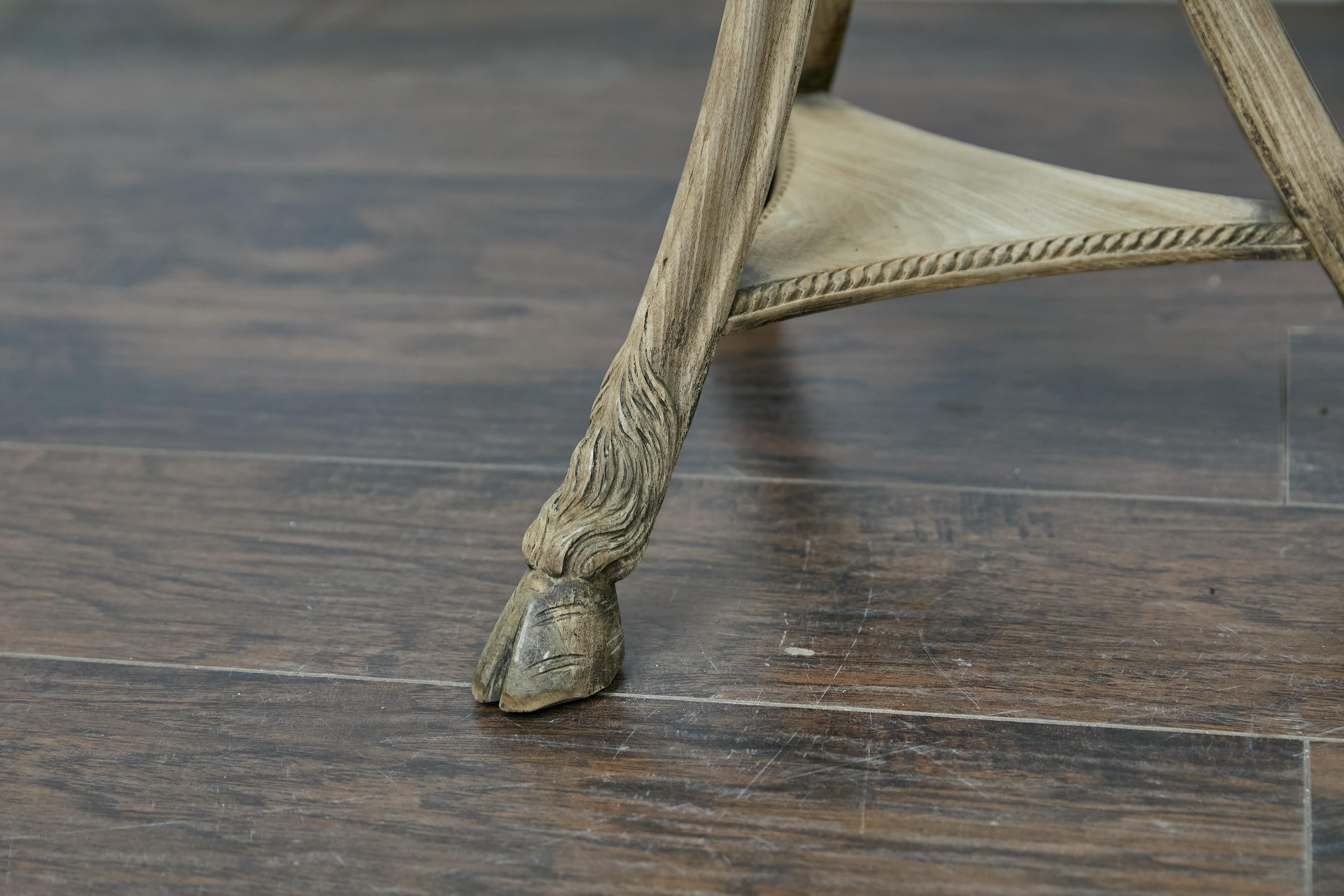 Italian oak tripod pedestal side table from the early 20th century with zebra top, carved ram's heads and hoof feet. This extraordinary Italian pedestal table boasts a rich blend of artistry and natural elegance, making it a striking addition to any