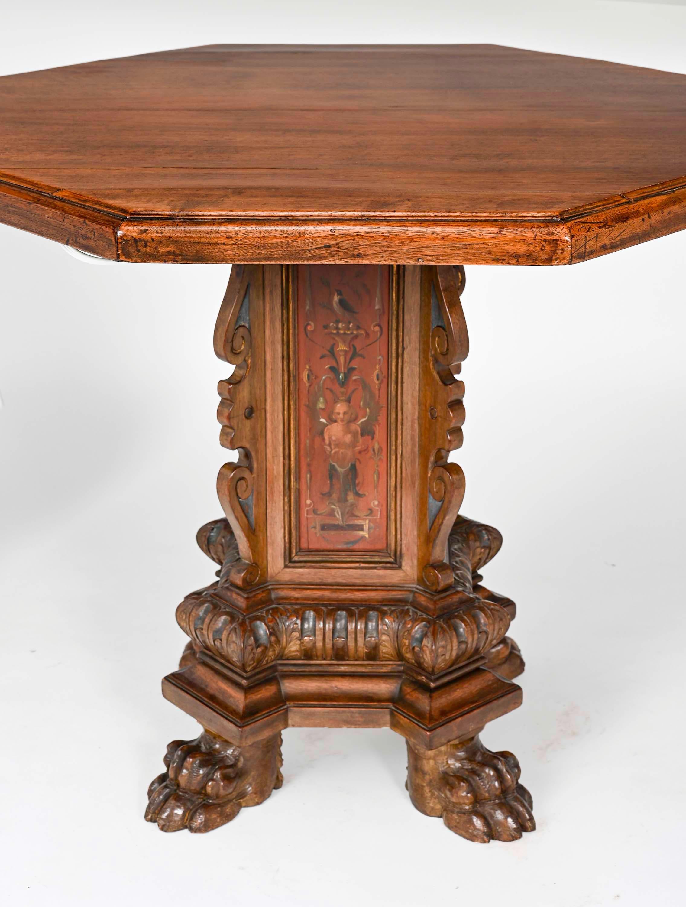 Antique Italian octagon shape walnut table with carved pedestal base. Pedestal is four panels decoratively painted in polychrome, supported by beautifully carved lions feet. Great size for occasional table or center table.