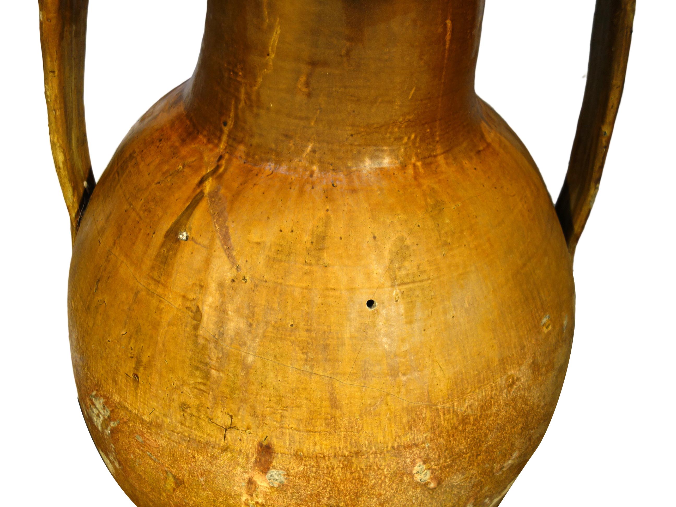 Antique Italian Orcio Puglia large terracotta vessel with ochre & umber glaze.
Authentic Mediterranean antique pottery, two-handled amphora jar with lower spout from Apulia region of southern Italy. Handcrafted earthenware of terracotta with unique