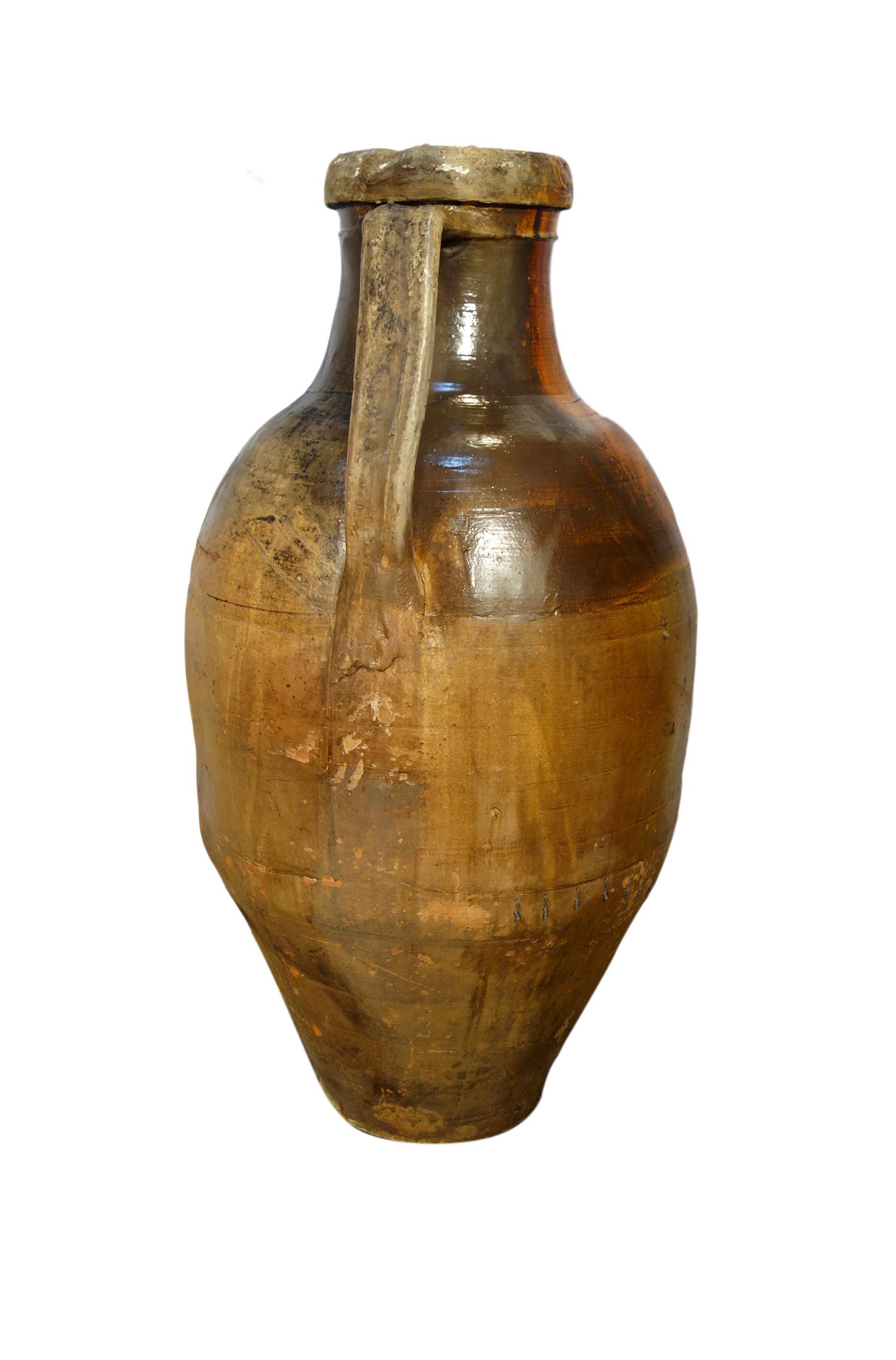Antique Italian Orcio Puglia; large terracotta vessel with ochre & umber glaze.
Authentic Mediterranean antique pottery, two-handled amphora jar from Apulia region of southern Italy. 
Handcrafted earthenware of terracotta with unique Majolica