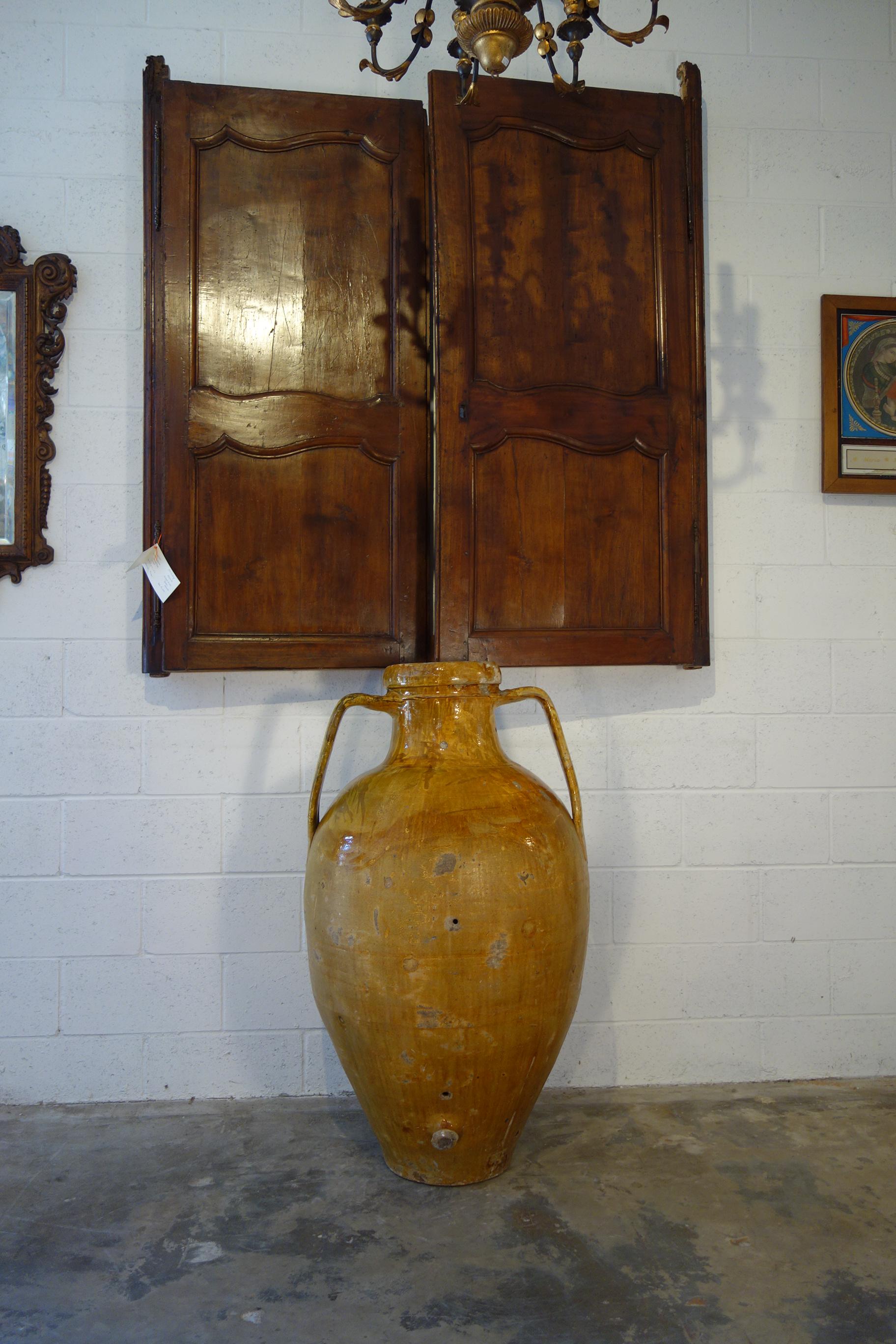 Mediterranean antique pottery, two-handled orcio jar with lower spout from Apulia region of southern Italy.  Handcrafted earthenware vessels of terracotta with unique Majolica enamel glaze. Once used for storage and shipping jars for wine and olive