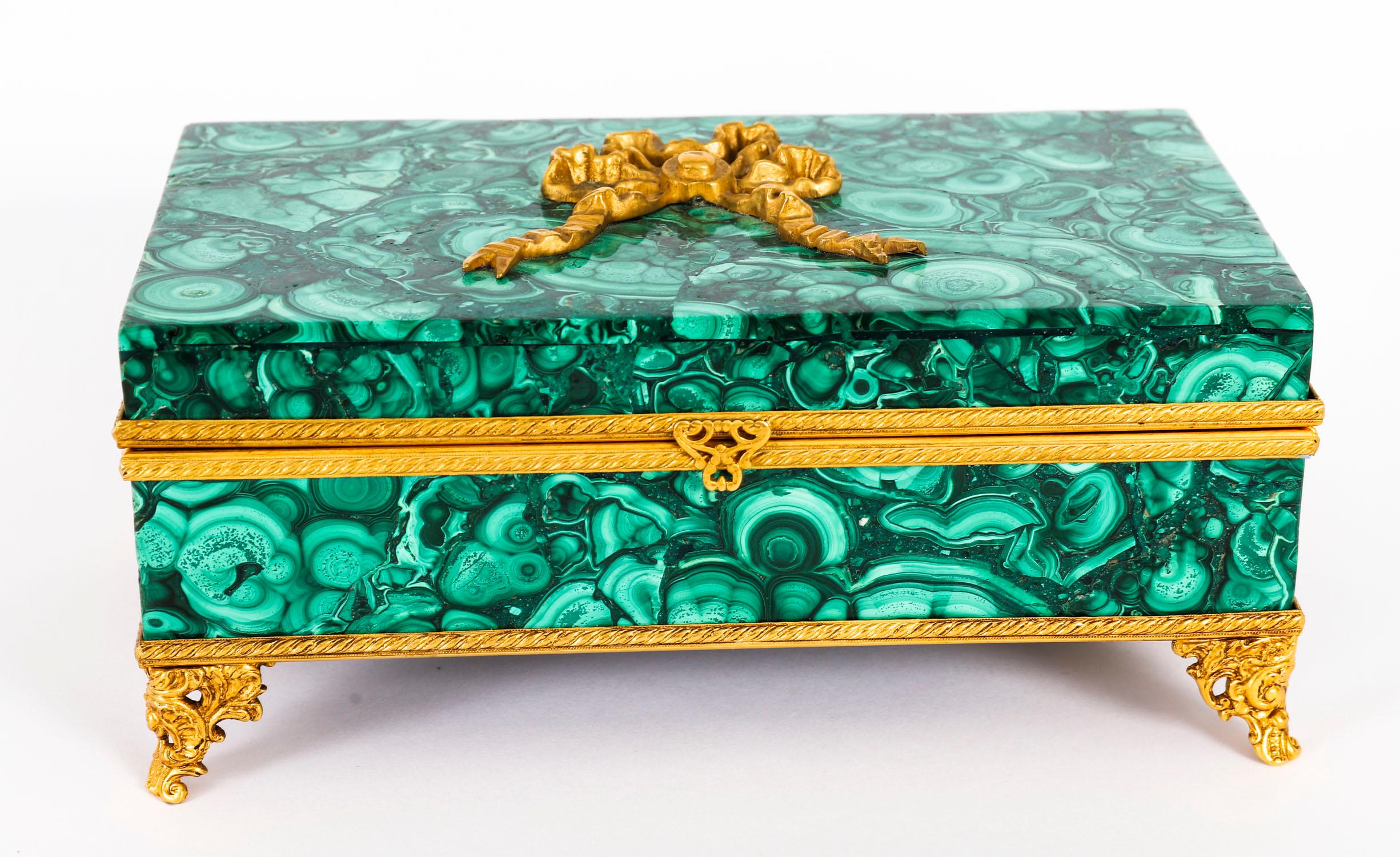A superb quality antique Italian Ormolu mounted Malachite jewellery casket, circa 1900 in date.

The rectangular casket is veneered in panels of malachite, the hinged lid is mounted with a 24k gold plate gilt bronze ribbon-tied crest and the borders