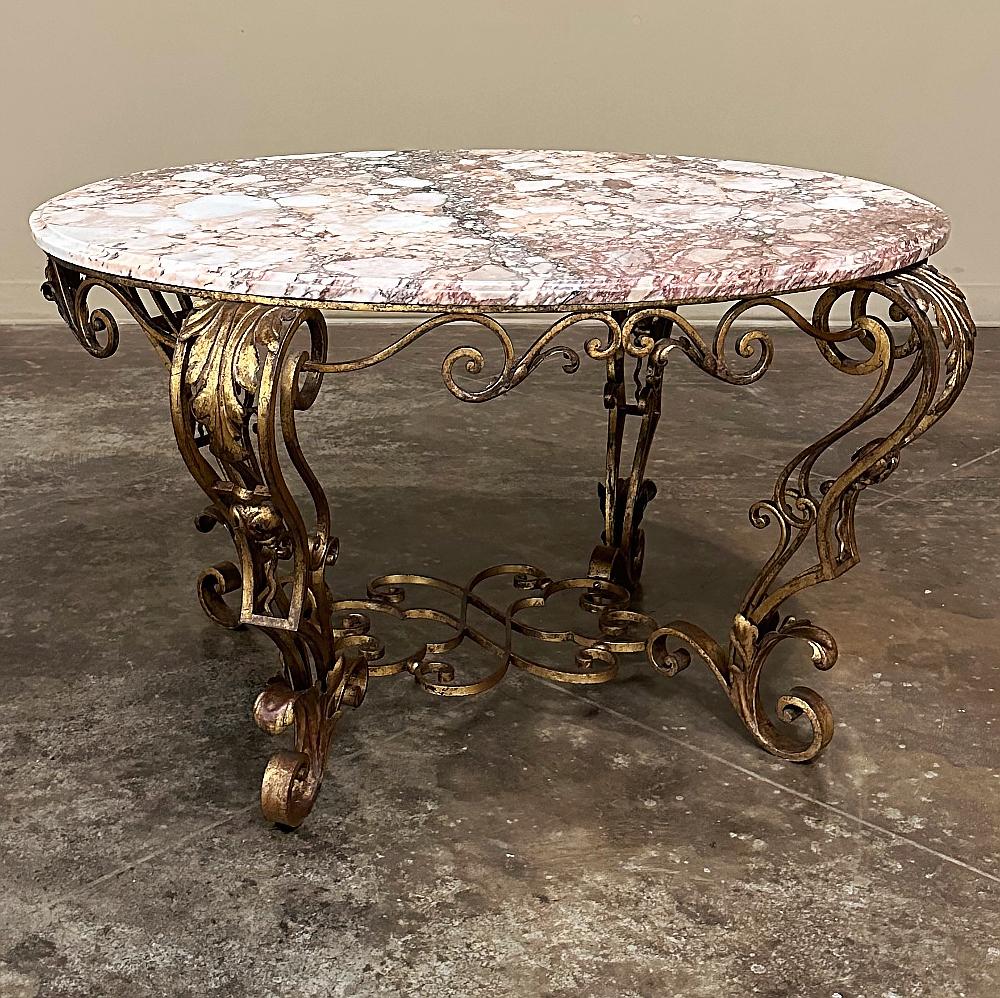 Antique Italian Painted Wrought Iron Marble Top Coffee Table will bring a taste of the splendor of Louis XIV style to your room!  Topped with luxuriously veined marble that mixes alabaster with gray and neutral tones, its oval shape with beveled