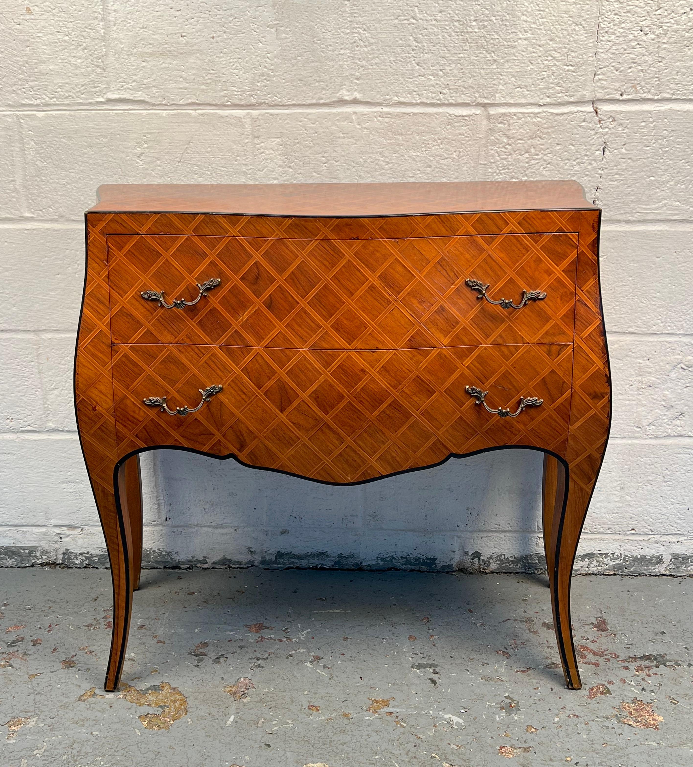 Striking Italian commode, featuring an intricate parquetry design across its facade. The piece combines geometric detailing with a refined silhouette, offering both storage and elegance. A distinctive addition that highlights Italian craftsmanship