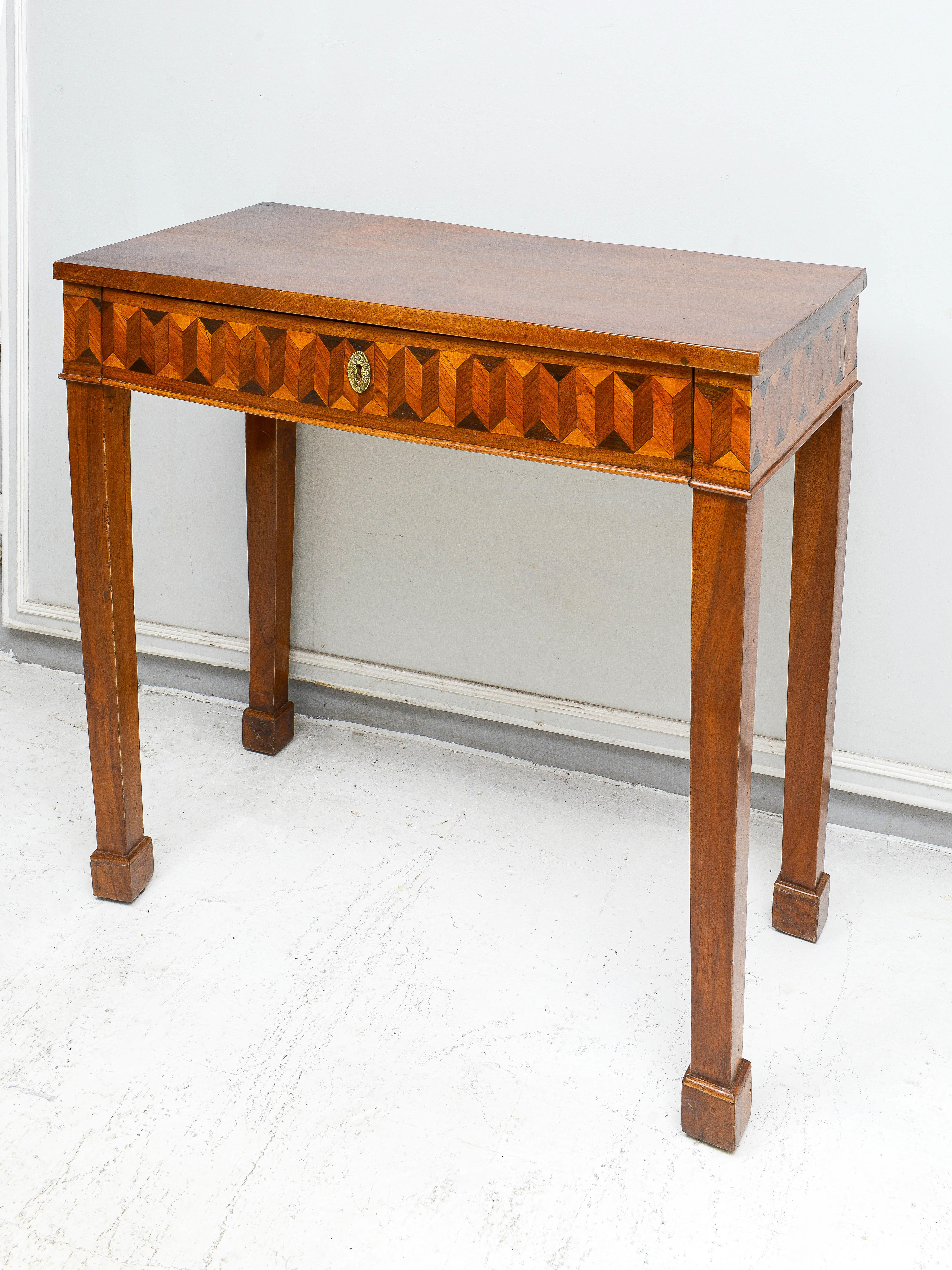 Finely crafted antique Northern Italian parquetry console. The parquetry work consist of several different types of wood — mahogany, walnut, satinwood and  ebony. The console has a central drawer.