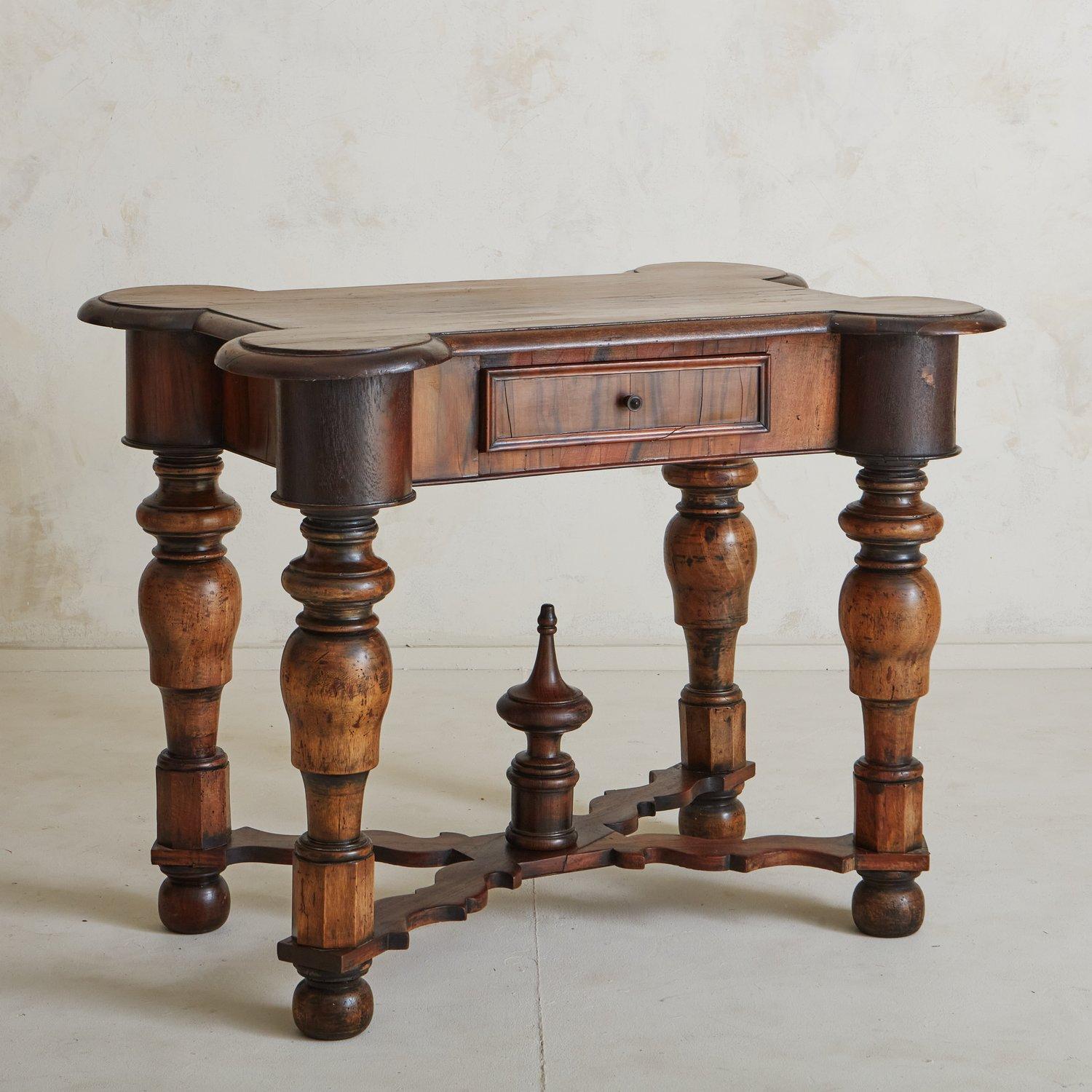 A beautiful antique gueridon sourced in Italy. This gueridon was hand carved with pear and cherry wood and features four intricately turned legs with an ornate X-stretcher punctuated by an oversized decorative finial. The rectangular tabletop has